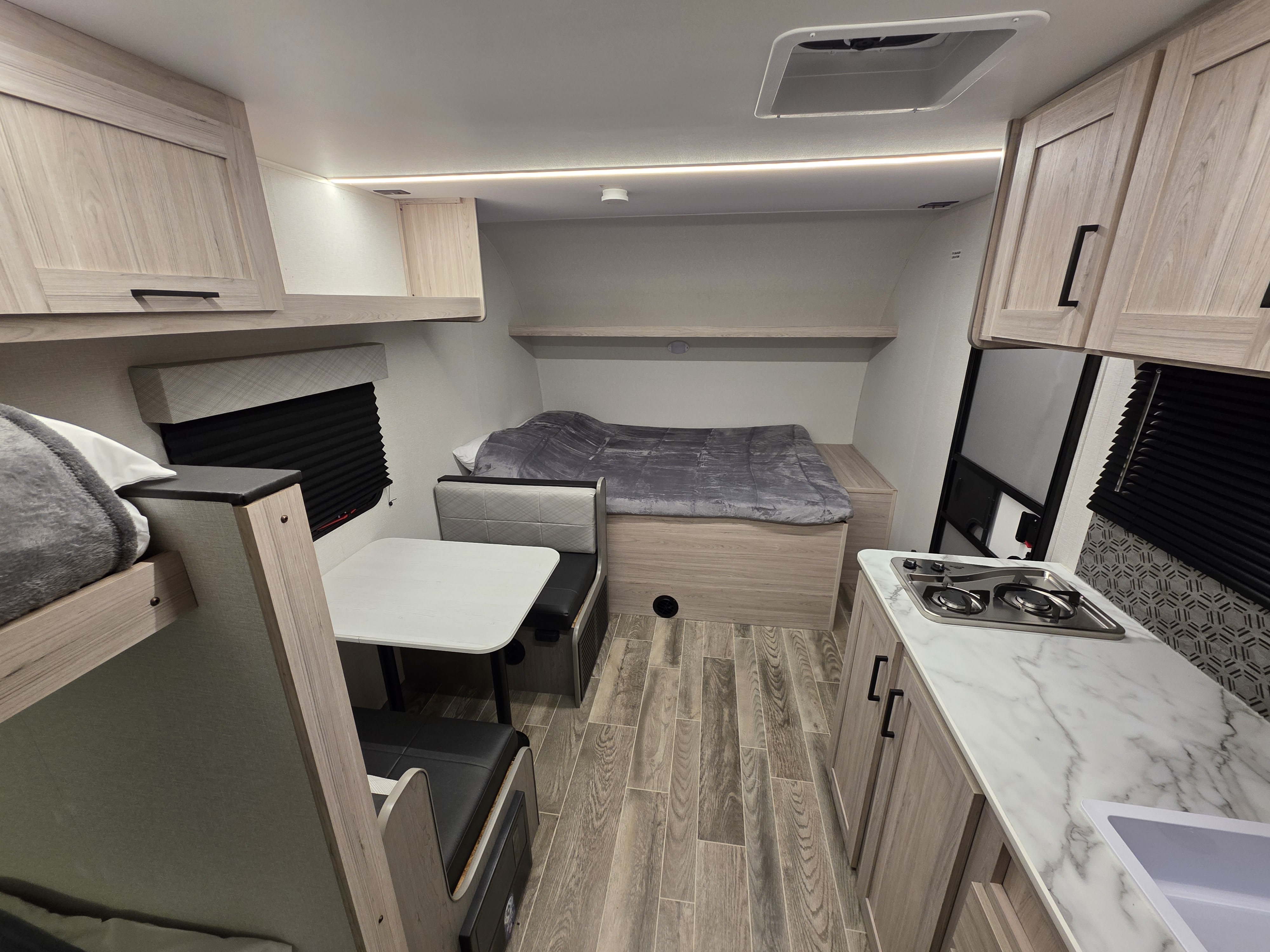 Compact RV rental with modern interior: bunk beds, dinette, kitchen, and main bed. Light wood and bright lighting.. Heartland Mallard Switch 2025