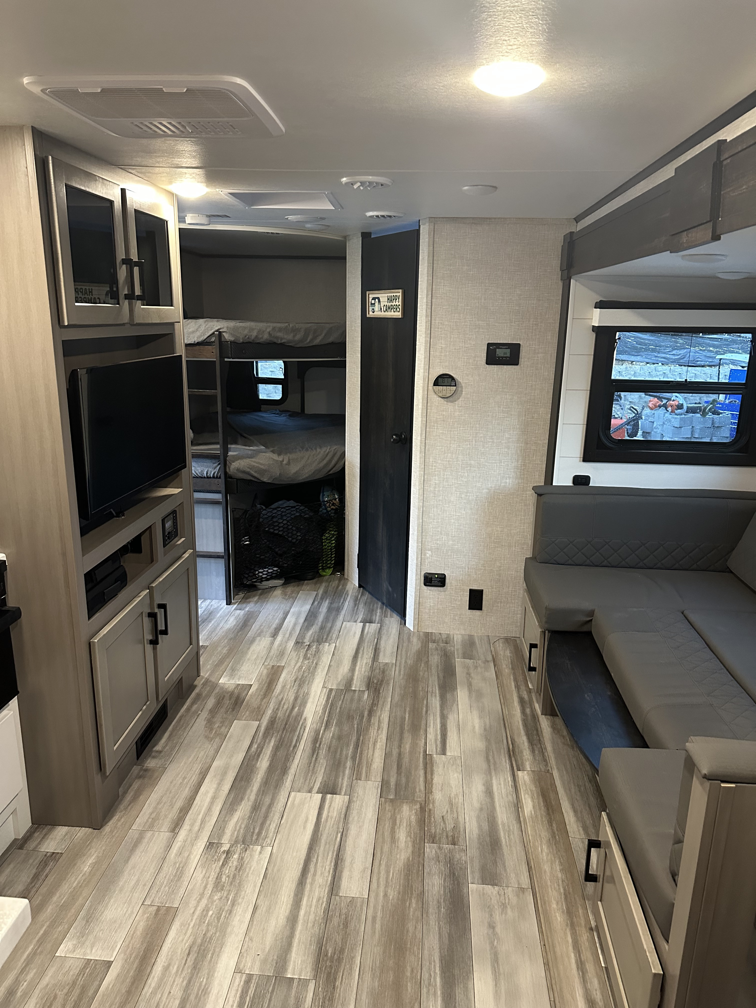 Spacious RV rental interior: modern living space with sofa, TV, and bunk beds. Ideal for campers!. Jayco Jay Feather 2024