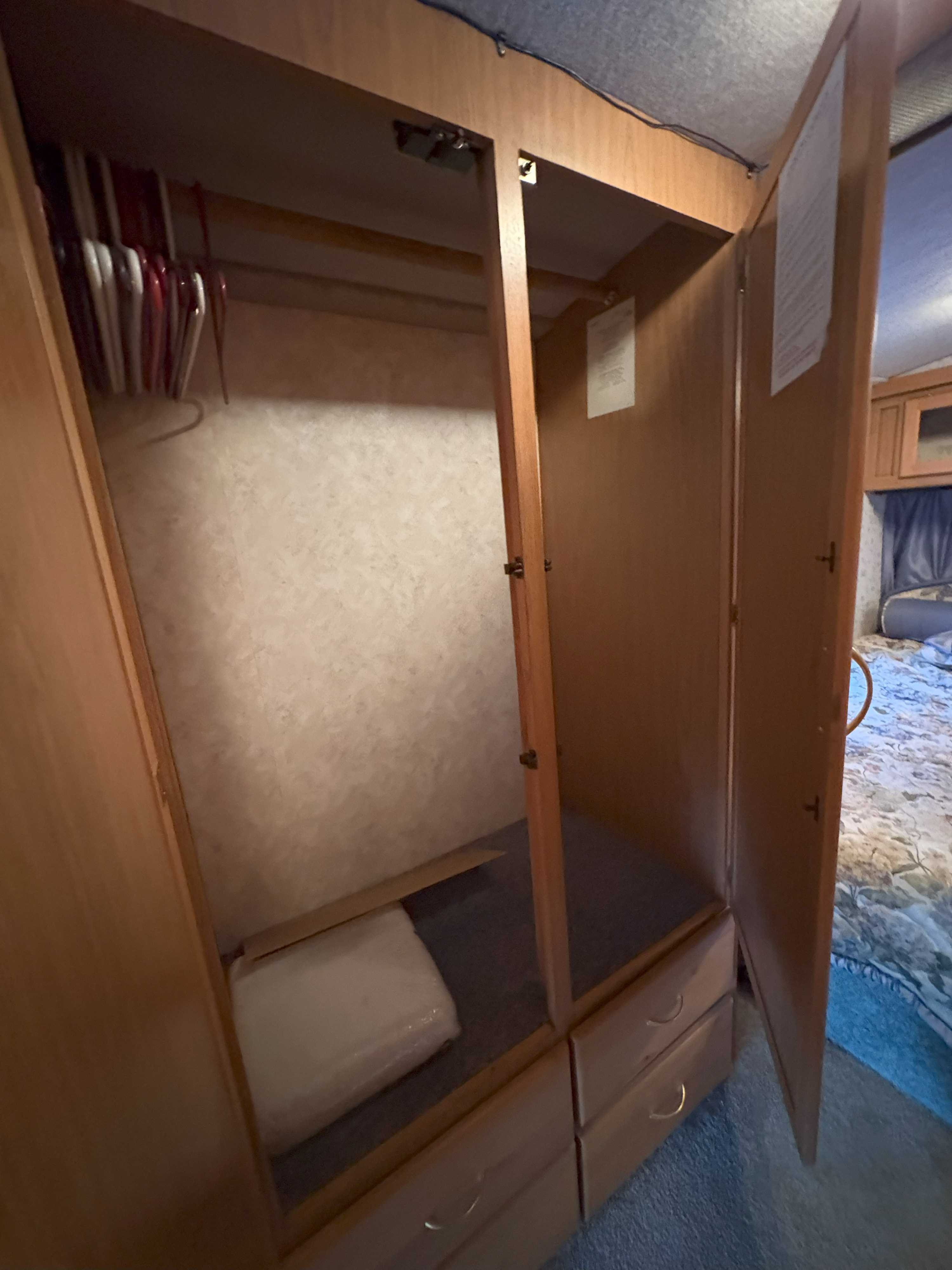 This RV rental features a well-equipped closet with a hanging rod, multiple hangers, and two lower drawers for ample storage.. Fleetwood Southwind 1998