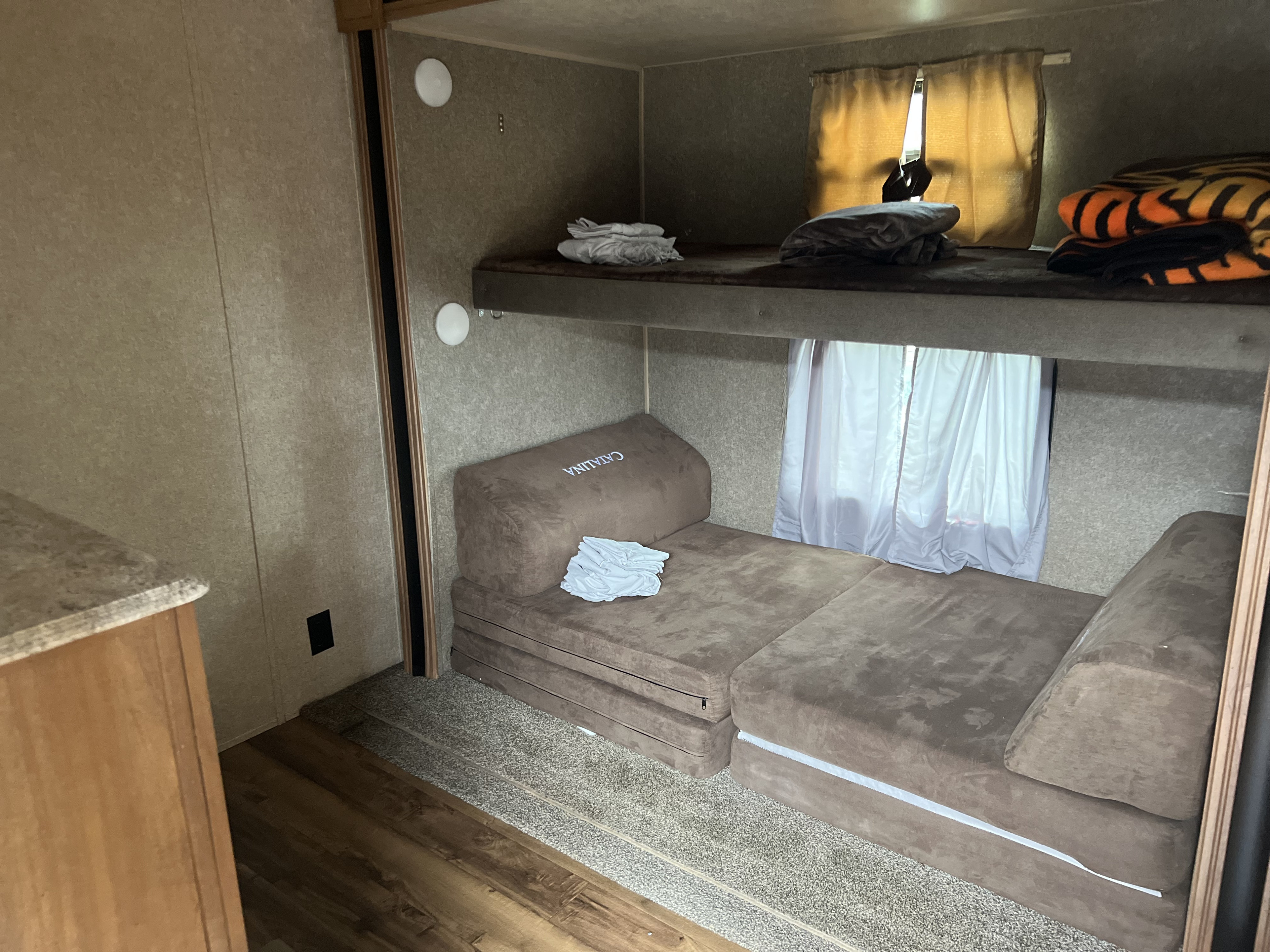 RV rental bunk beds: upper bed with blankets, lower features a versatile folding mattress for sleeping or seating.. Coachmen Catalina 2018