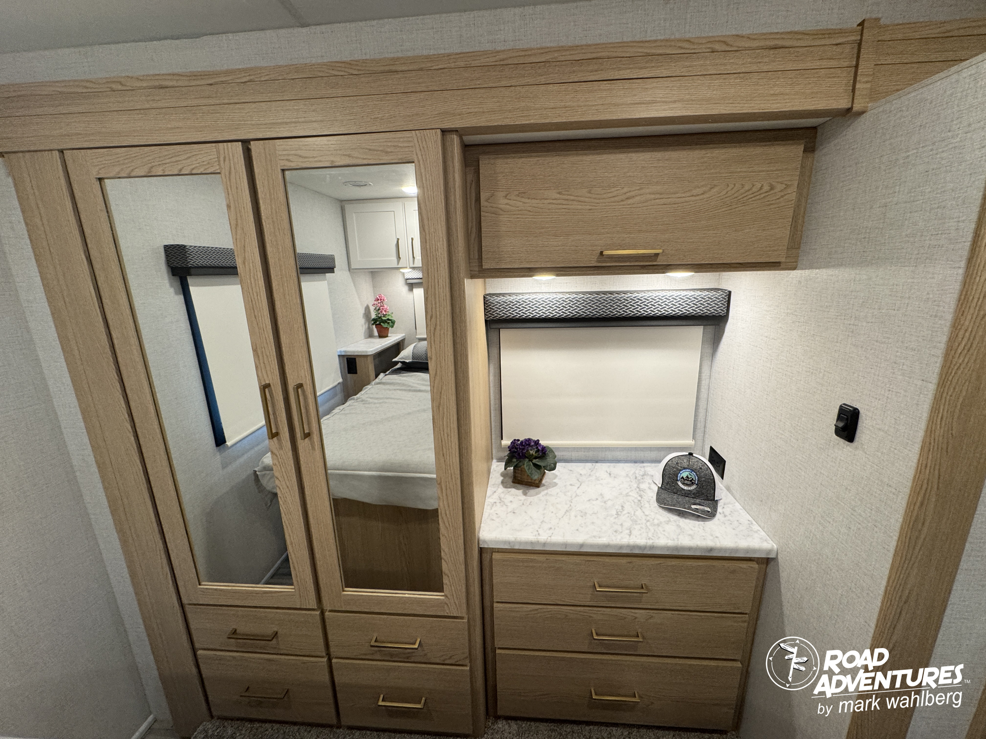 Cozy RV rental bedroom with wardrobe, mirrored doors, and dresser for storage. Ready for travel!. Thor Motor Coach Four Winds 2026