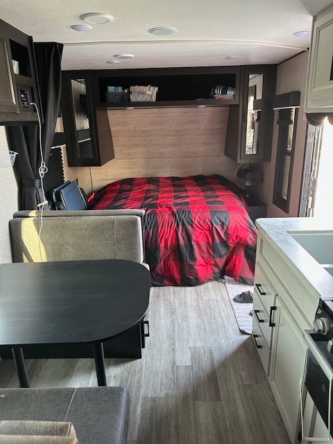 Modern RV rental living space featuring a comfortable bed, dinette, and well-equipped kitchen.. Jayco Jay Flight 2023
