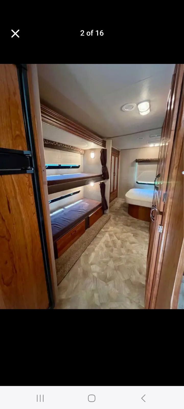 Interior of an RV rental featuring two comfortable bunk beds on the left, a rear bed, and light wood cabinetry.. Jayco Redhawk 2016