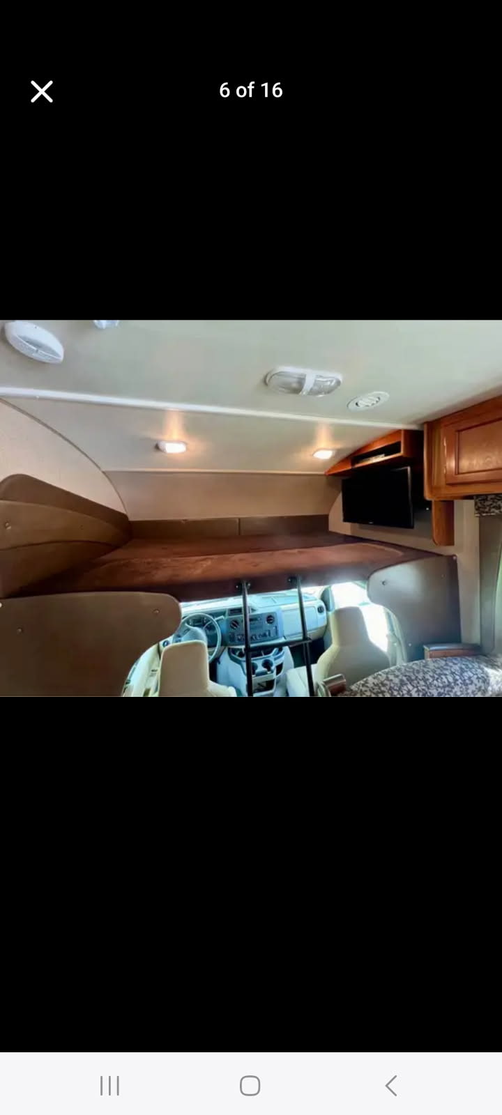This RV rental interior features an overhead bed, driver's cockpit, and mounted TV. Brightly lit and ready for adventure.. Jayco Redhawk 2016