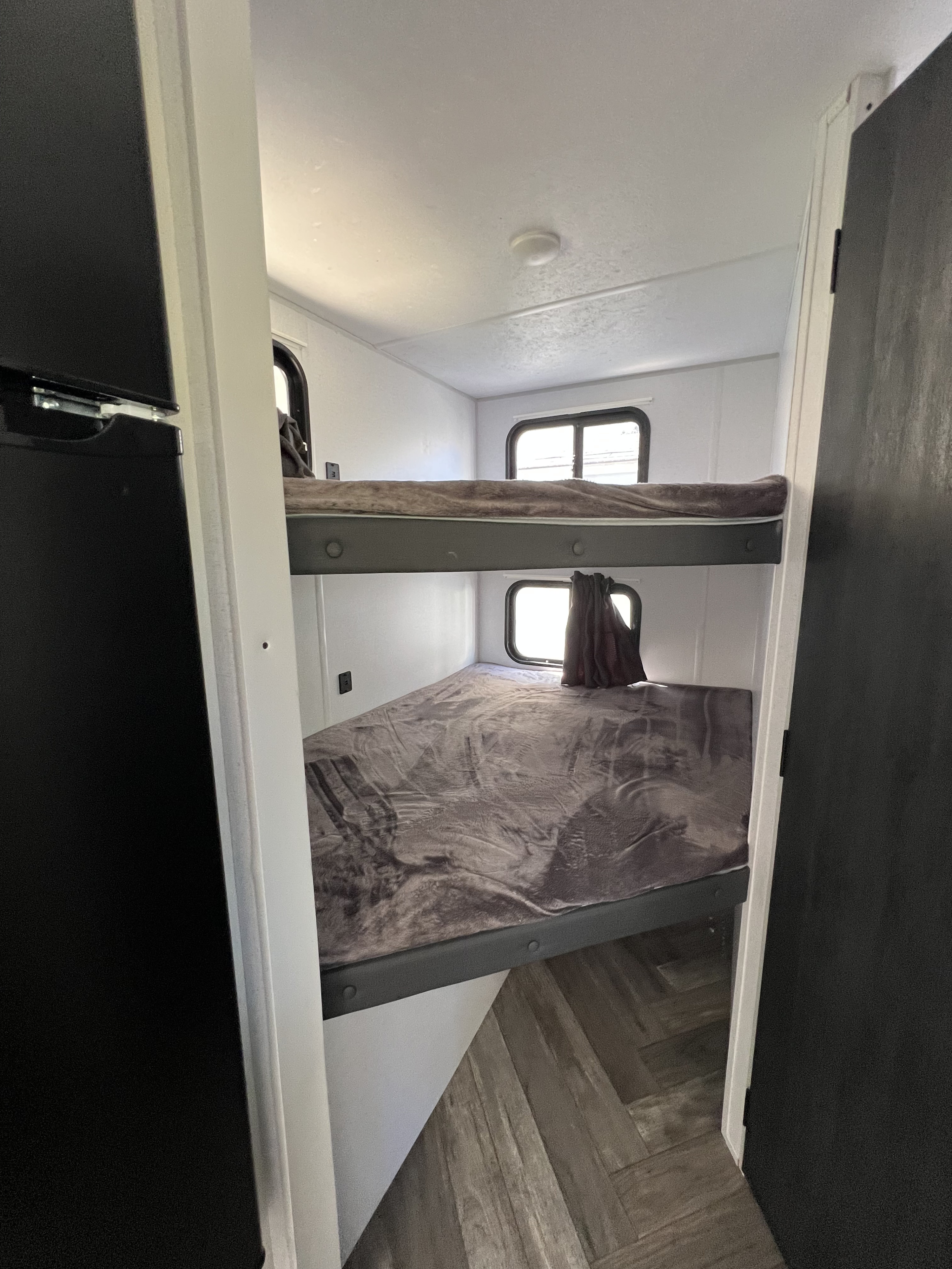 Spacious RV rental features twin bunk beds with soft blankets & windows, providing cozy sleeping quarters.. Forest River Salem FSX 2021