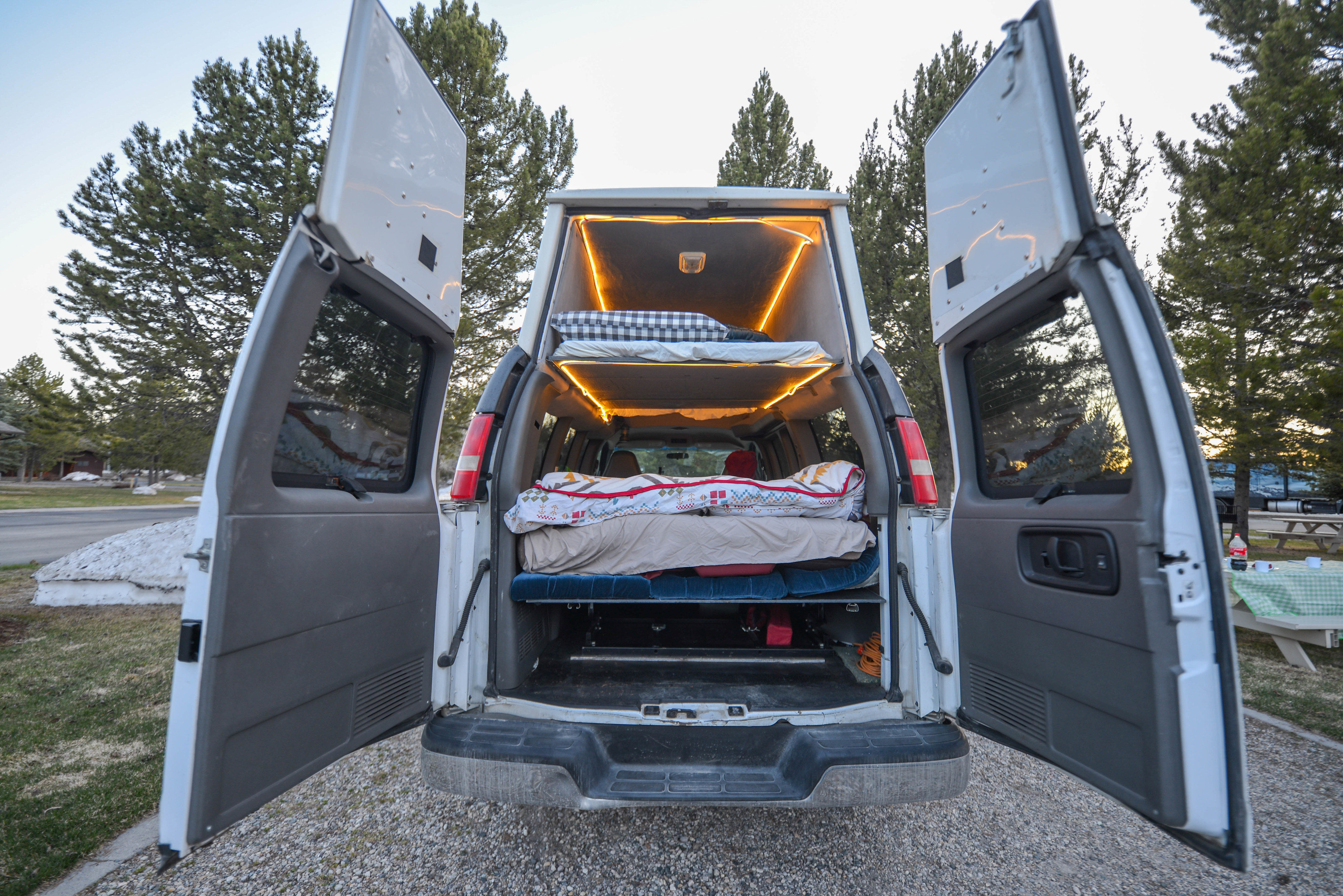 This RV rental van conversion features custom bunk beds and warm LED lighting, perfect for adventurers.. Chevrolet 3500 LS 2006