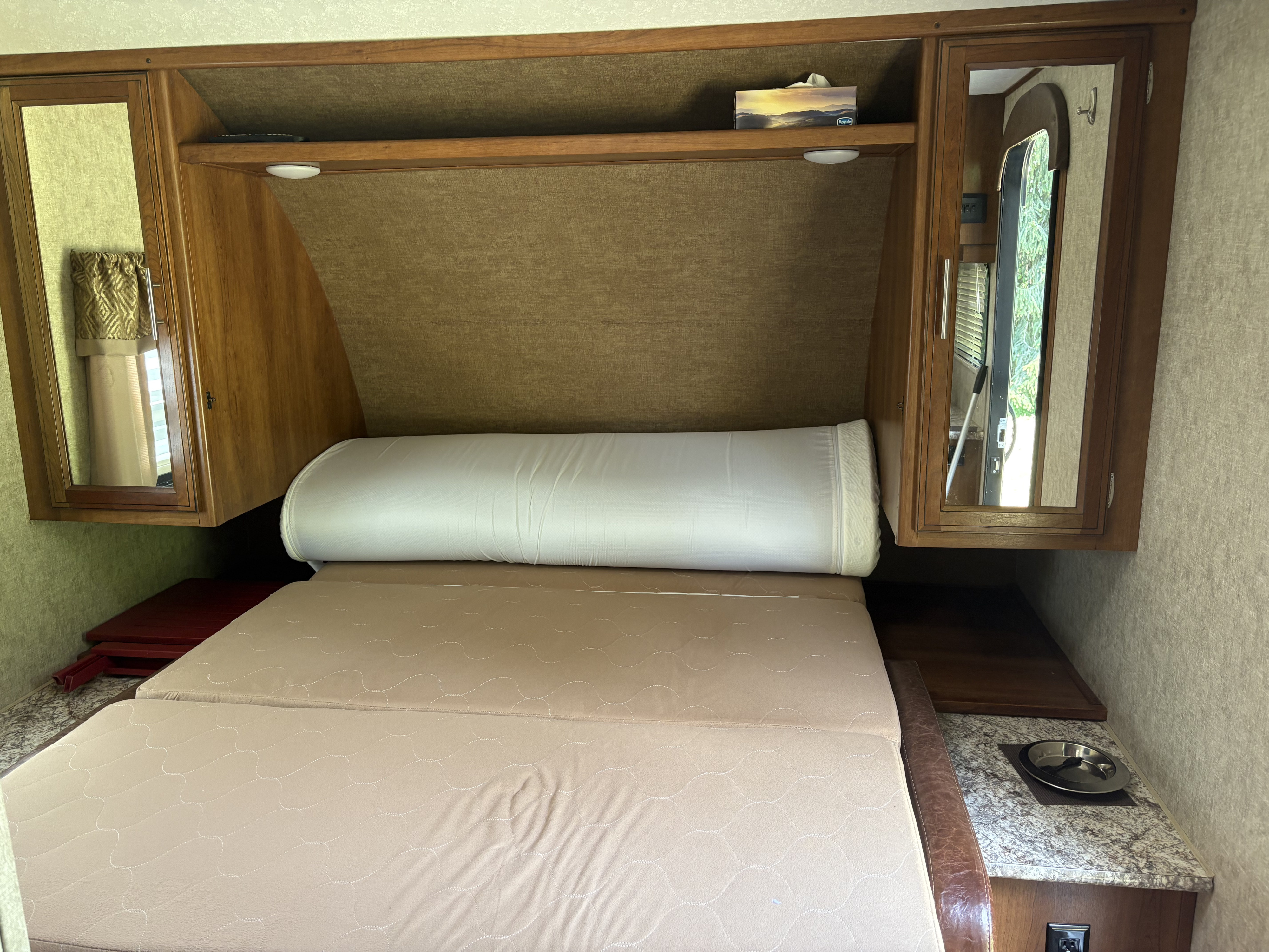 RV rental interior featuring a comfy bed, overhead storage, mirrored cabinets, and a pet bowl.. Tracer Tracer Air 2017