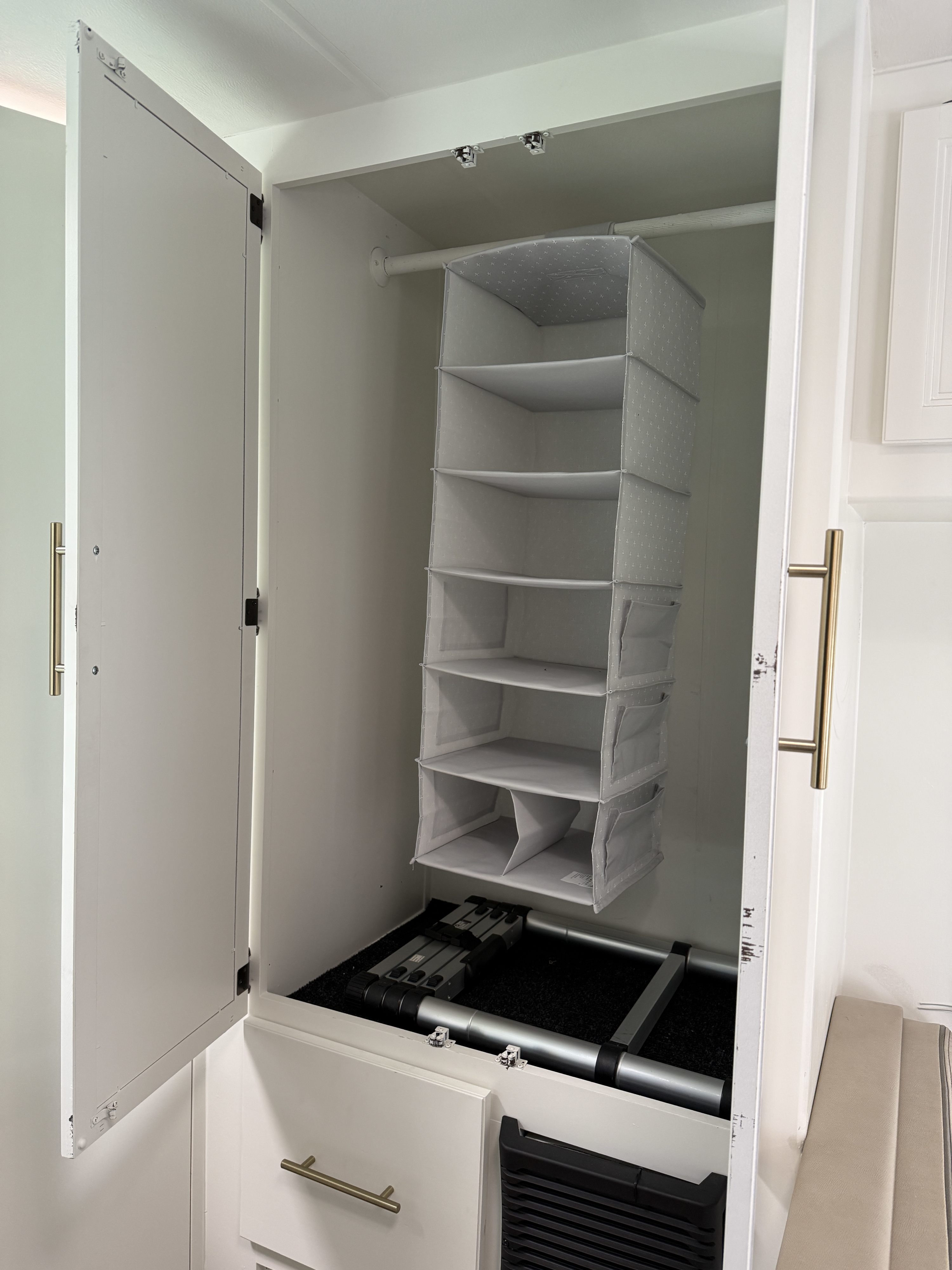 RV rental: A compact closet featuring a hanging fabric organizer, folded ladder, and efficient storage inside.. Thor Chateau 2022