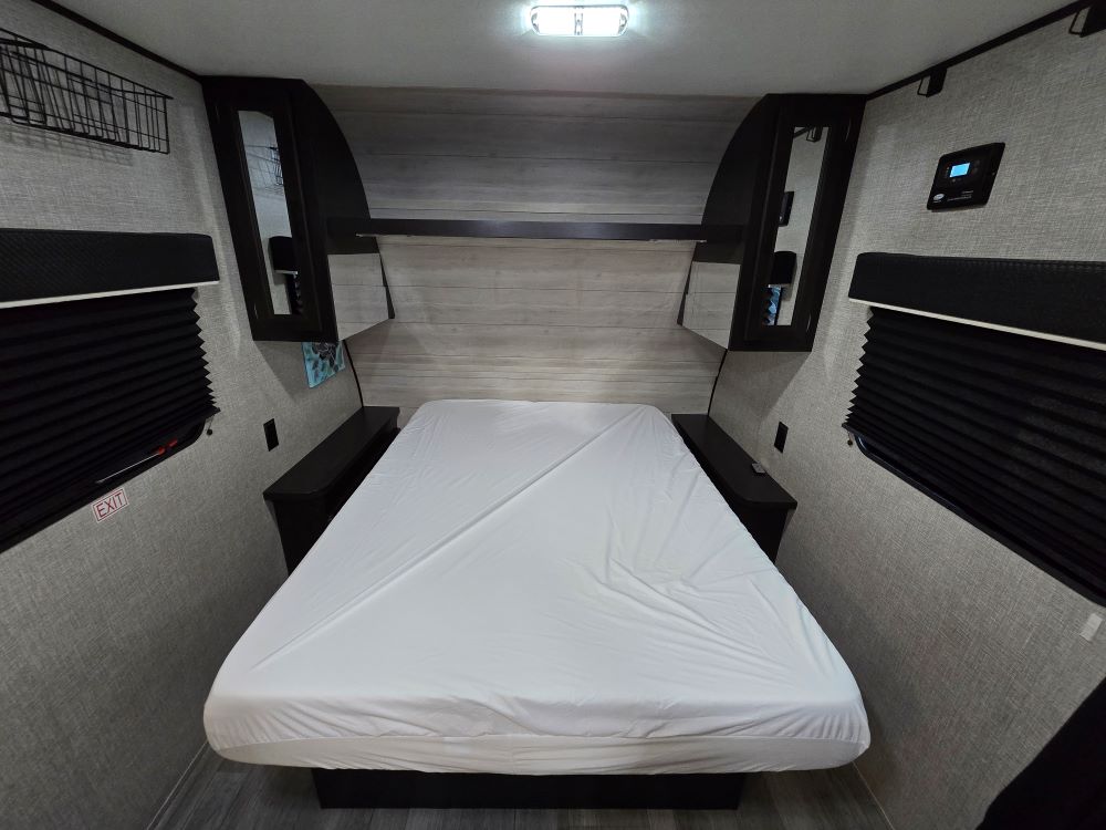 RV rental bedroom with bed, nightstands, overhead storage, and privacy window shades.. Jayco Flight 195RB 2022