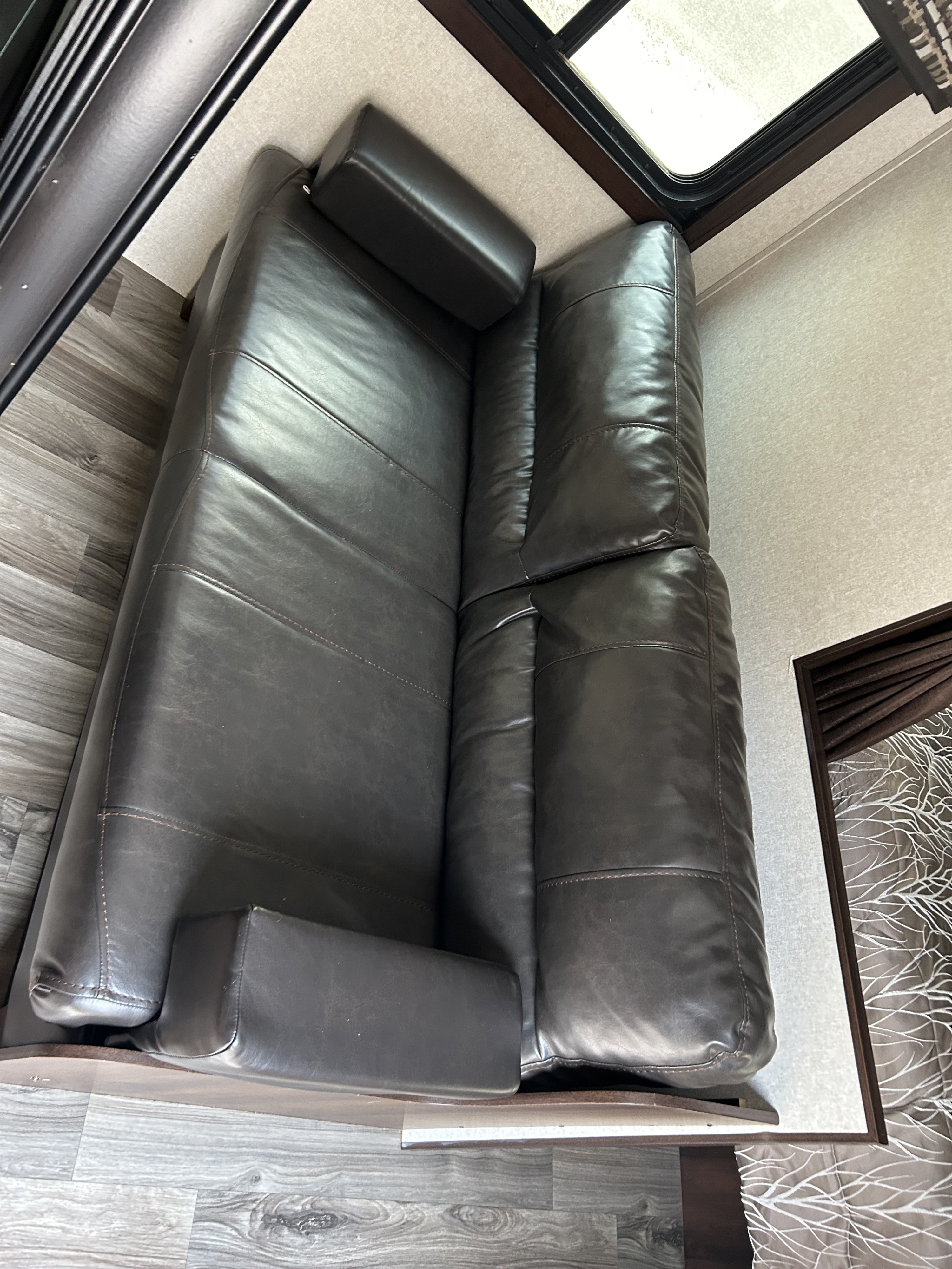 Cozy dark leather sofa in an RV rental, perfect for relaxing inside this comfortable vehicle interior.. Jayco Jay Flight 2018
