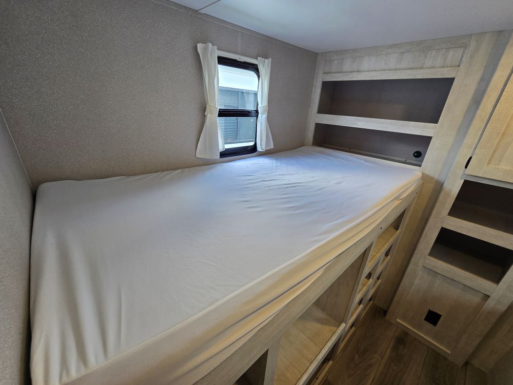 RV rental: Bright interior featuring a comfortable bunk bed with window and built-in storage for efficient travel.. Shasta Oasis 31OK 2024