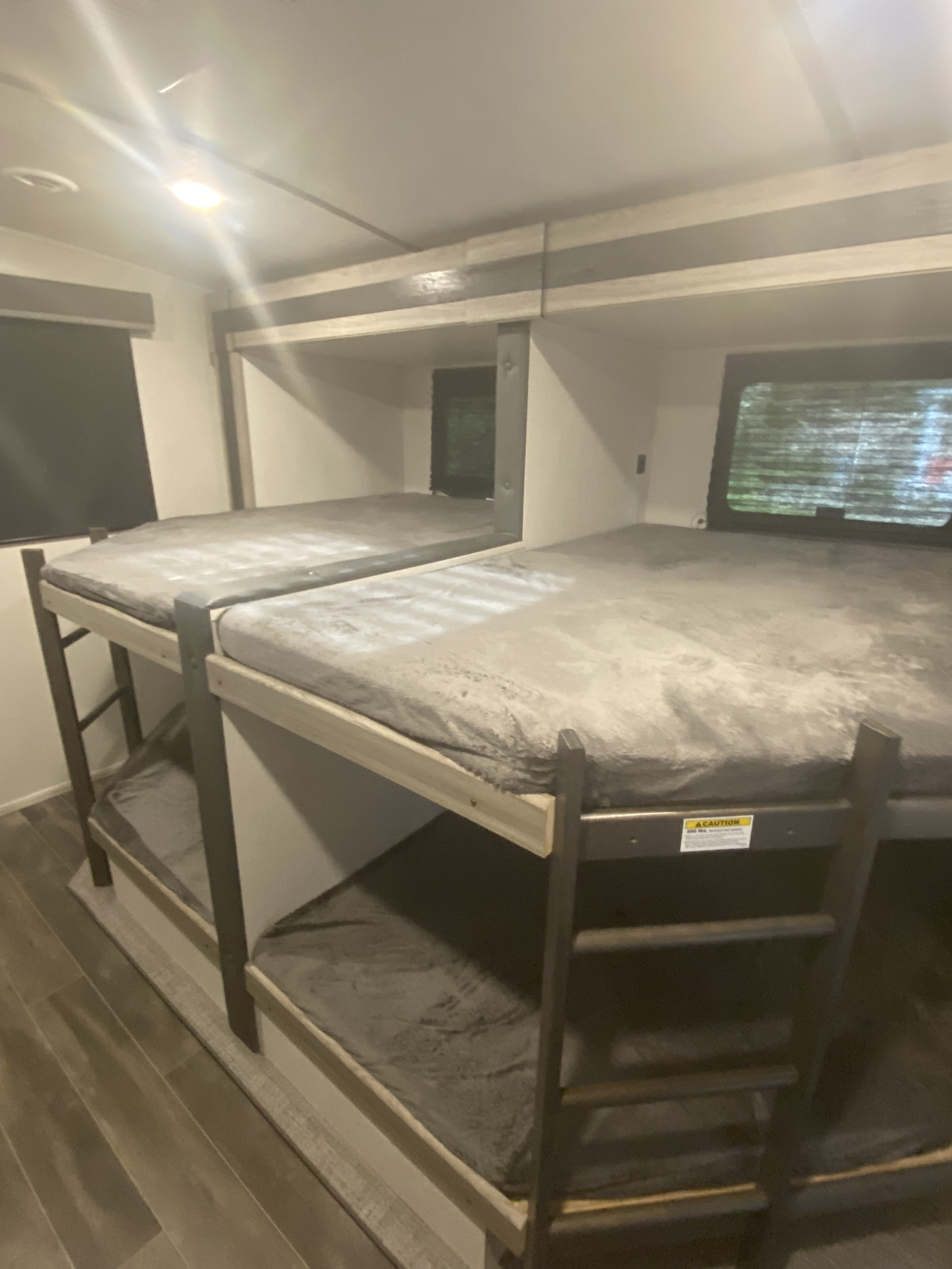 RV rental interior featuring four cozy bunk beds. Perfect for family adventures, offering comfortable sleeping spaces.. Keystone RV Passport GT 2022