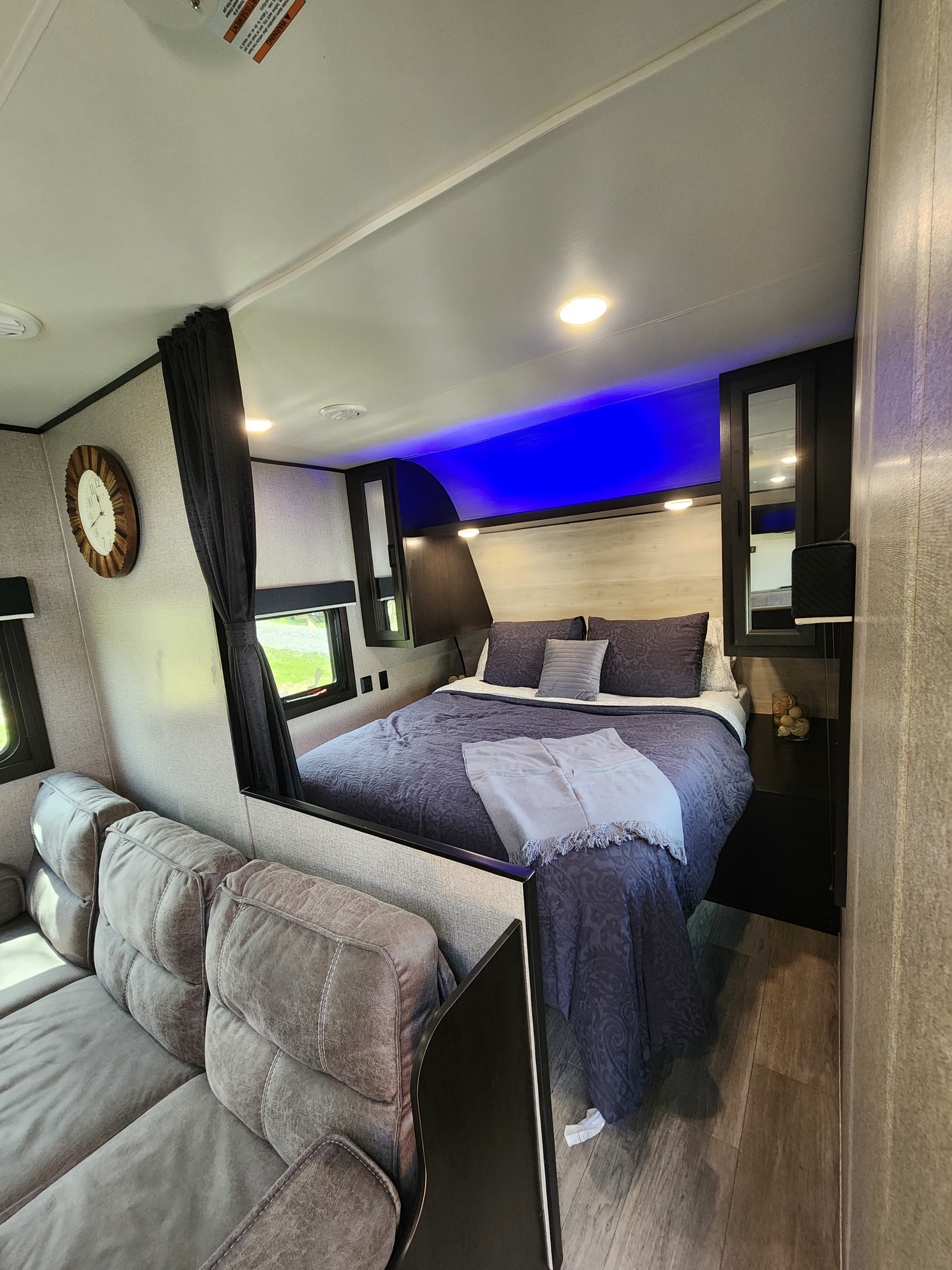 Cozy RV rental bedroom and living space featuring a comfortable bed, sofa, and ambient lighting for a relaxing journey.. Jayco Jay Flight SLX 2022