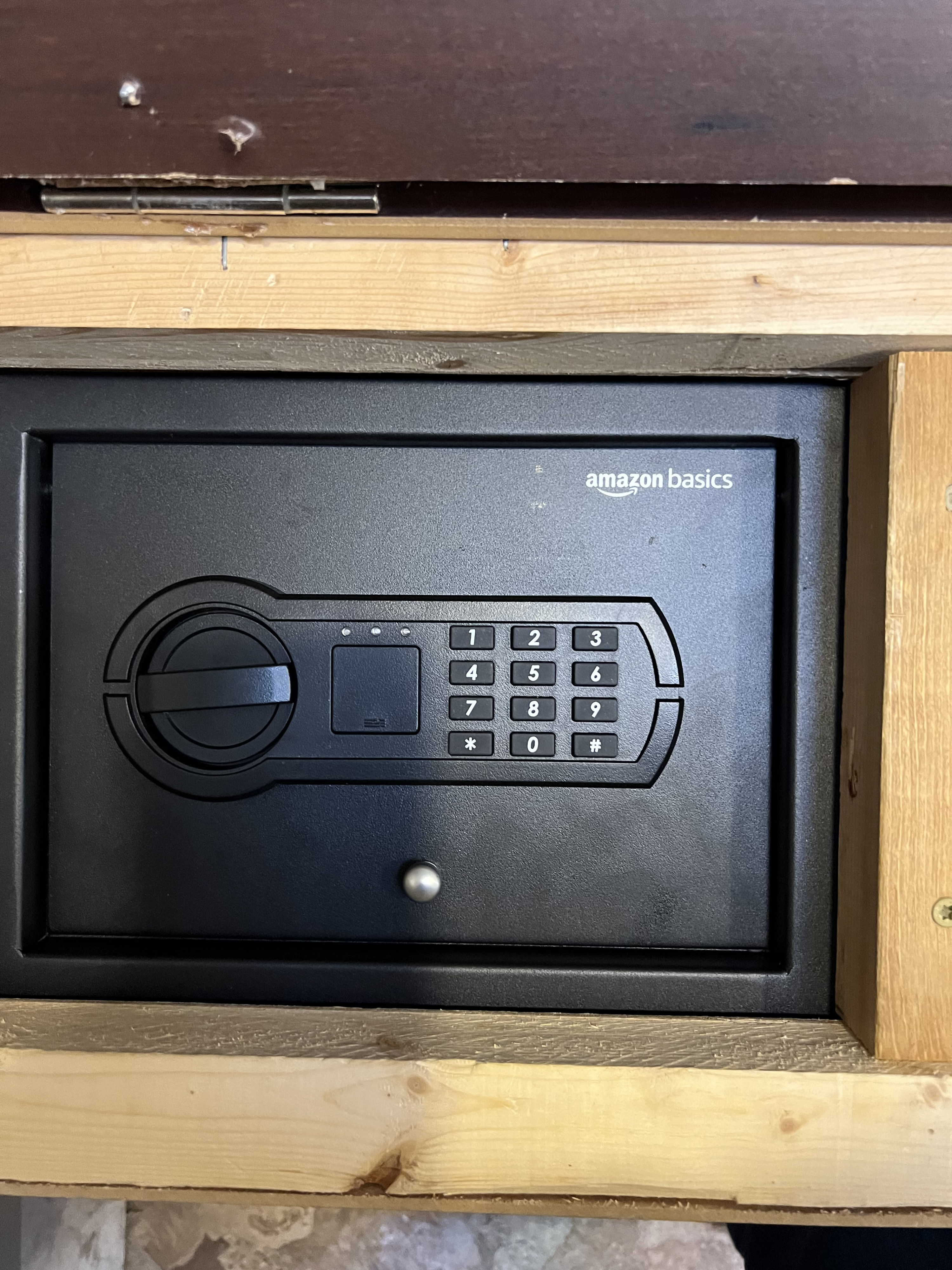 Close-up of an Amazon Basics digital keypad safe, integrated into a wooden cabinet for secure storage in an RV rental.. Thor Siesta 2017