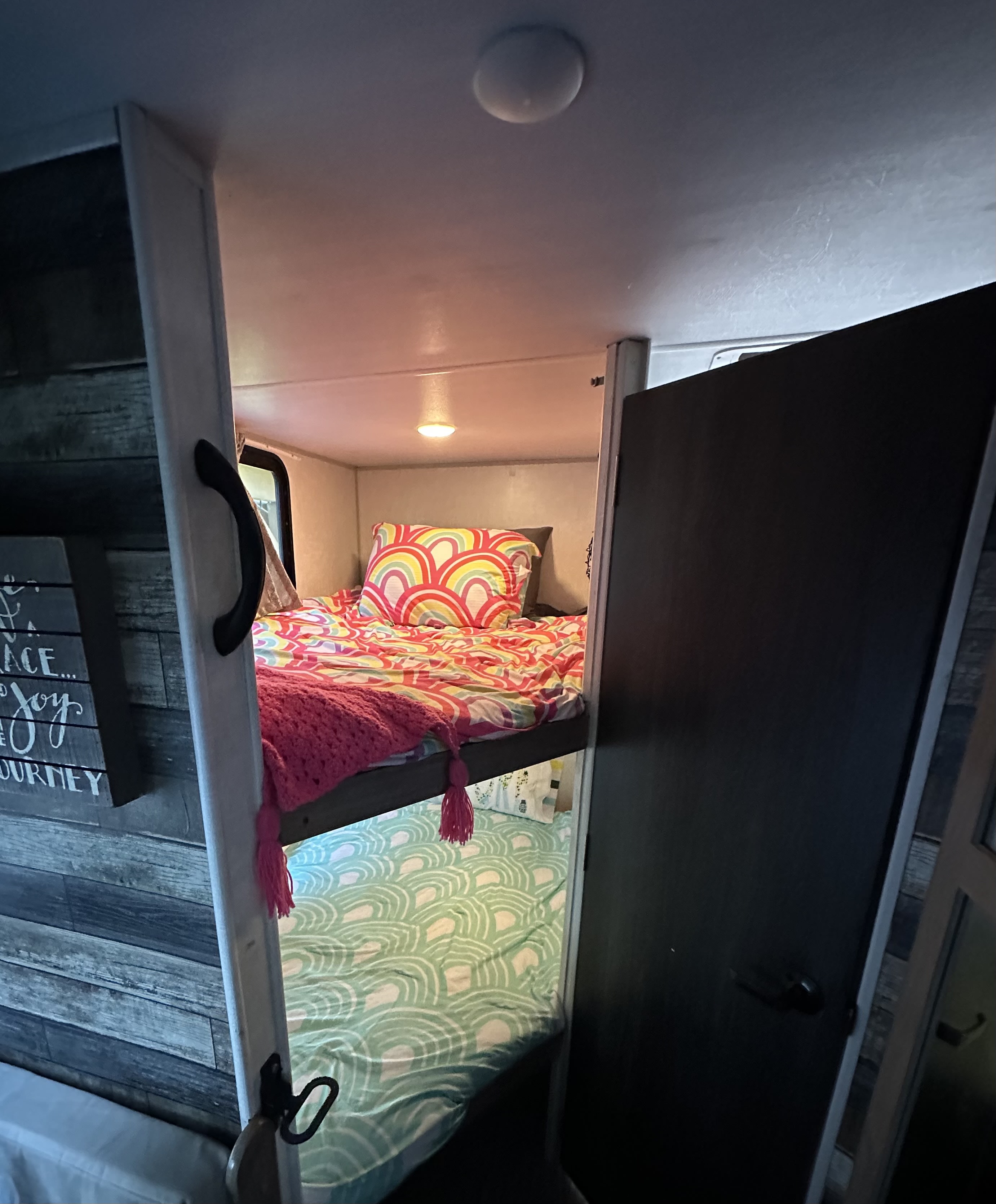 RV rental bunk beds: colorful top with rainbow, bottom with green patterns.. No Boundaries 19 2022
