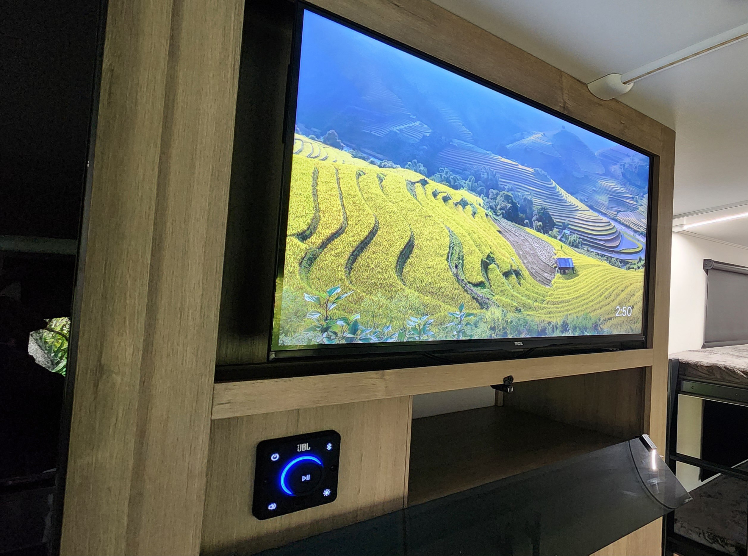 RV rental living space: Large TCL TV displaying scenic rice fields, JBL sound system, and bunk beds.. Grand Design Imagine 2800BH 2025