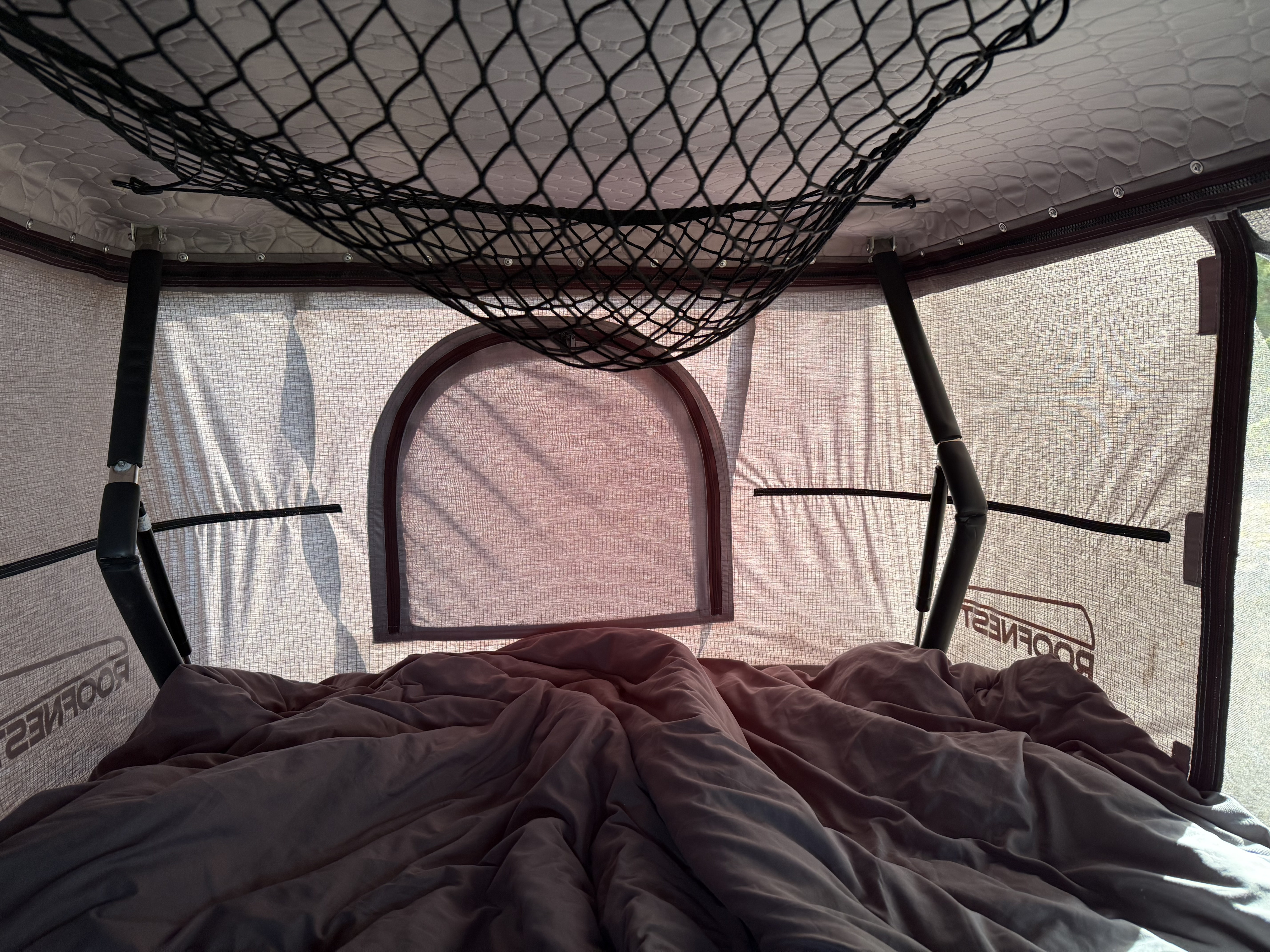 Cozy rooftop tent interior with bed, mesh window, and storage net for your next RV rental adventure.. Dodge Grand Caravan 2017