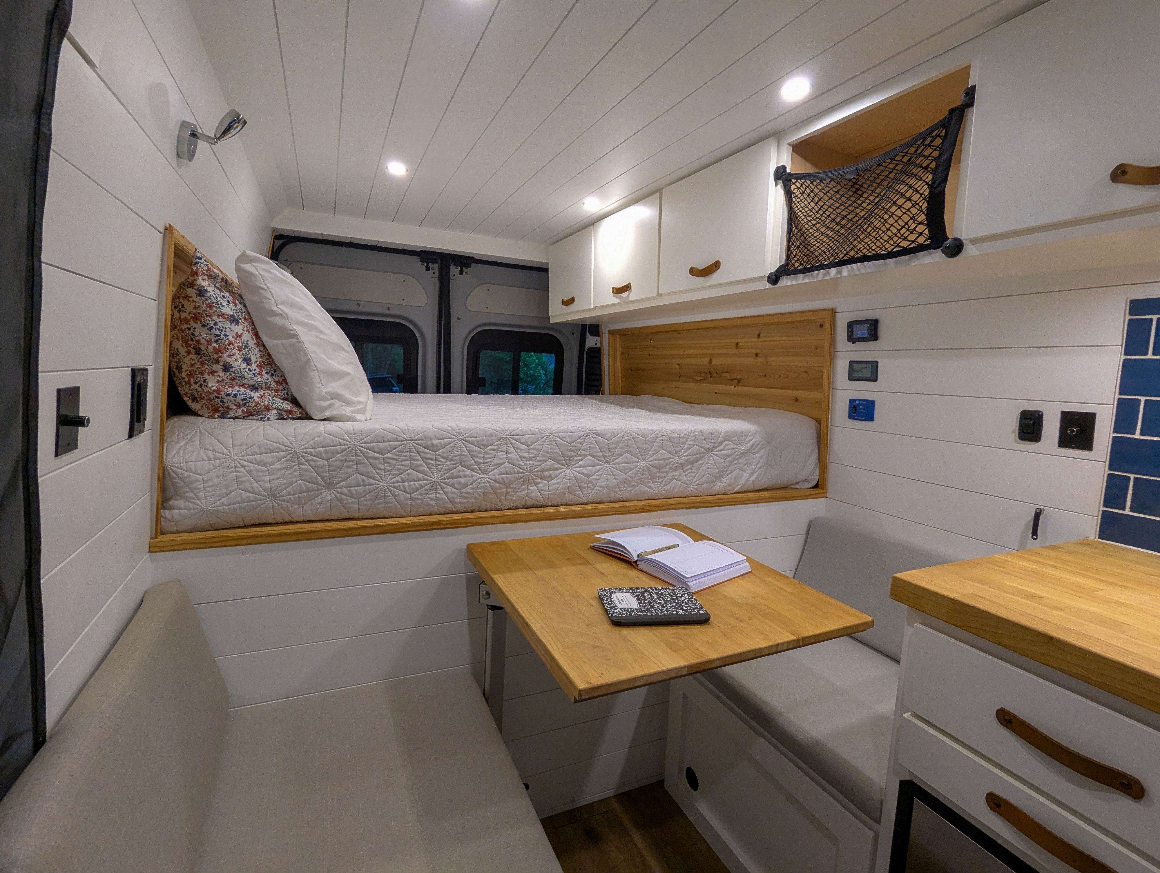 Step inside this RV rental: a well-designed camper van interior with a bed, dinette, and functional storage.. Dodge Ram Promaster 2500 2020