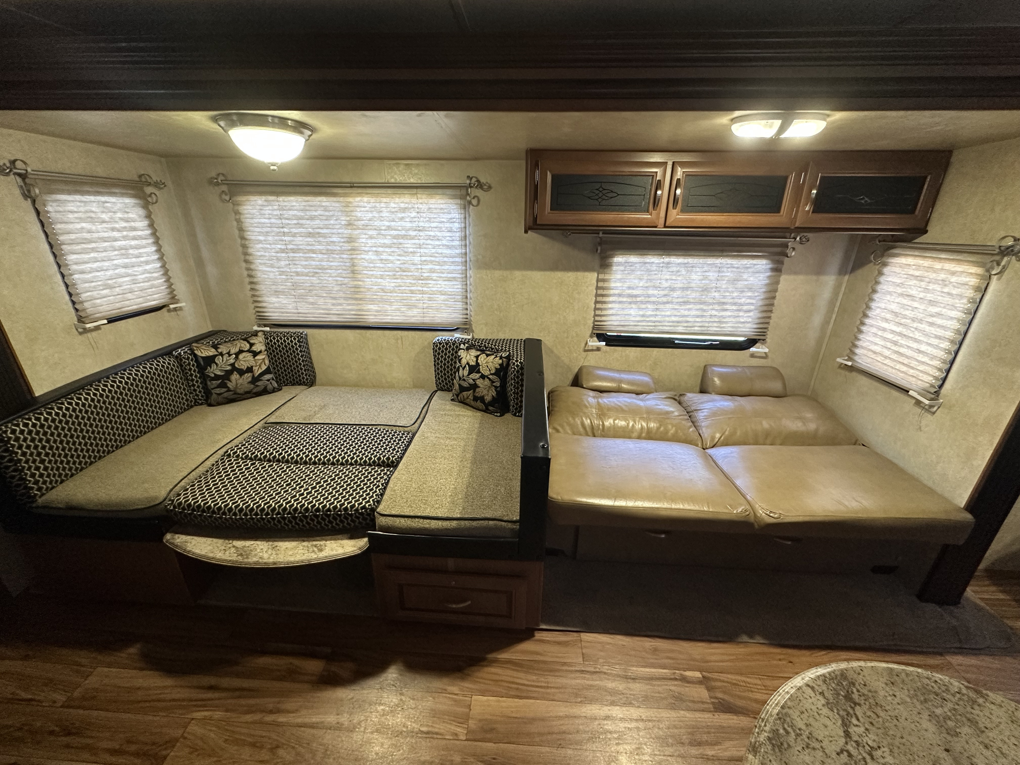 Spacious RV rental interior featuring a convertible dinette and a leather sofa, both adaptable for seating or sleeping.. Forest River Salem 2016