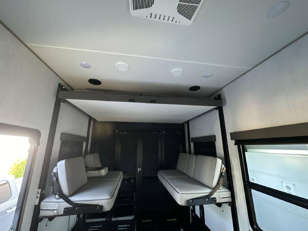 RV rental: Spacious toy hauler interior featuring versatile convertible bunk beds/sofas, ideal for adaptable travel living.. Grand Design Momentum 2024