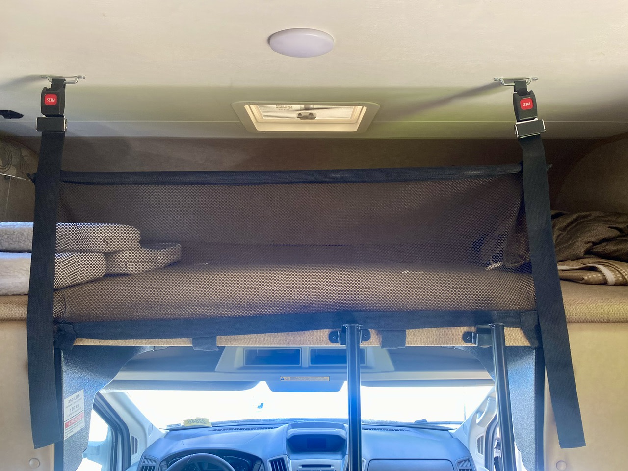 Black mesh safety net on an RV rental's cab-over bunk bed for secure travel.. Forest River Coachmen Freelander 2017