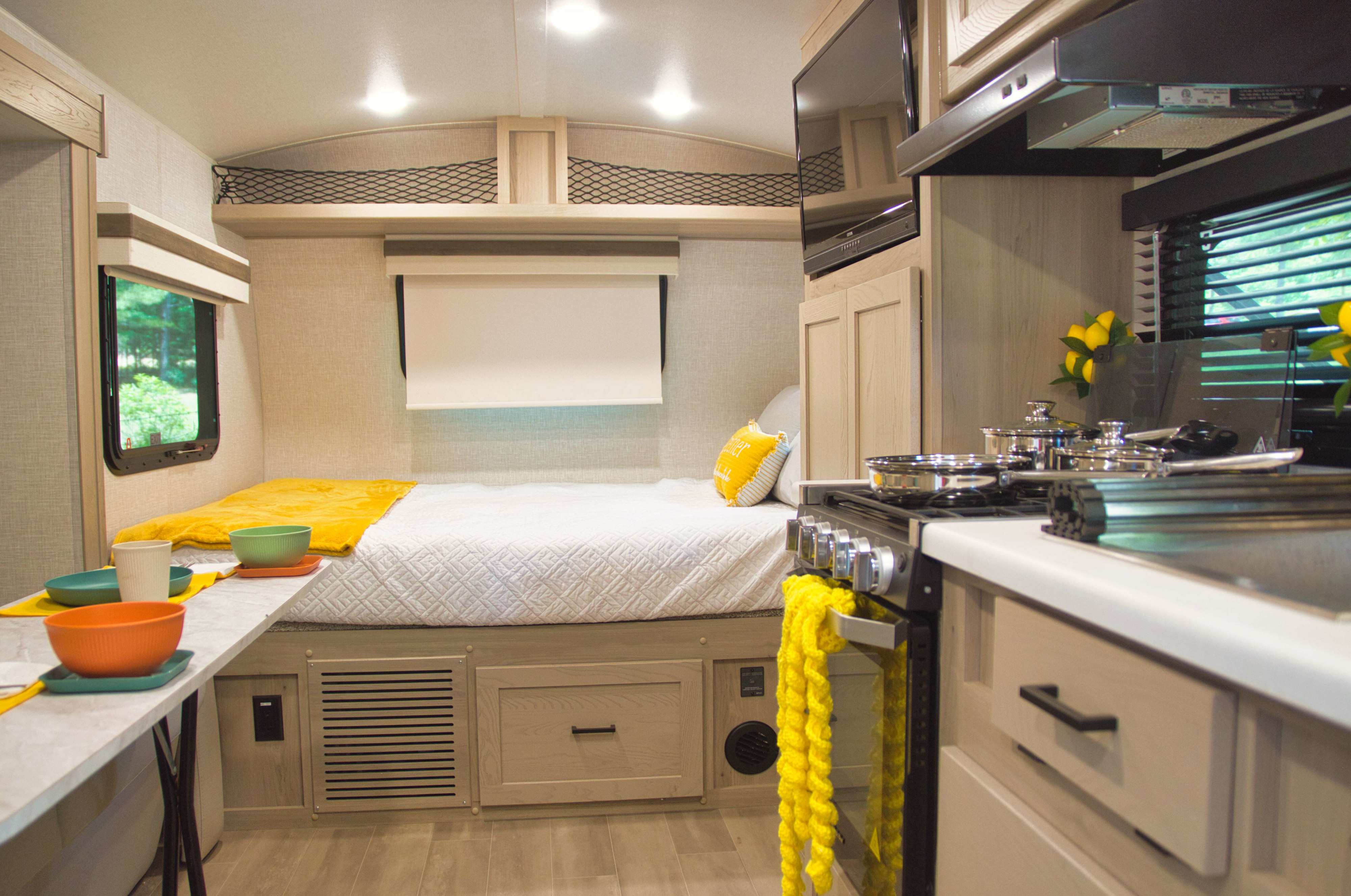Experience travel comfort! This RV rental offers a well-appointed interior with a cozy bed, modern kitchen, and dining space.. Forest River Rockwood 2024