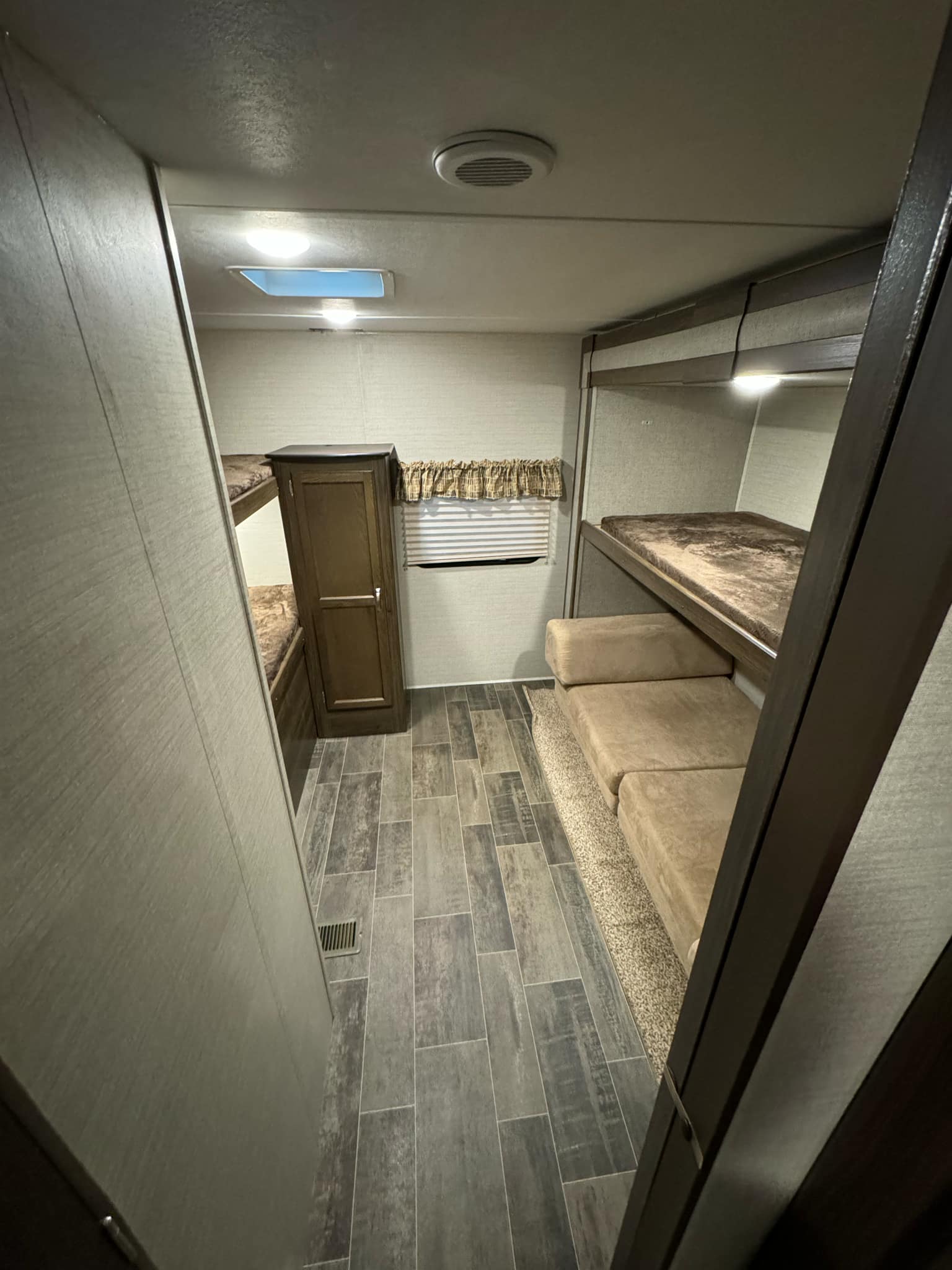 Step inside this RV rental, showcasing bunk beds, a wardrobe, and versatile sofa seating for comfortable travels.. Keystone RV Bullet Ultra Lite 2019