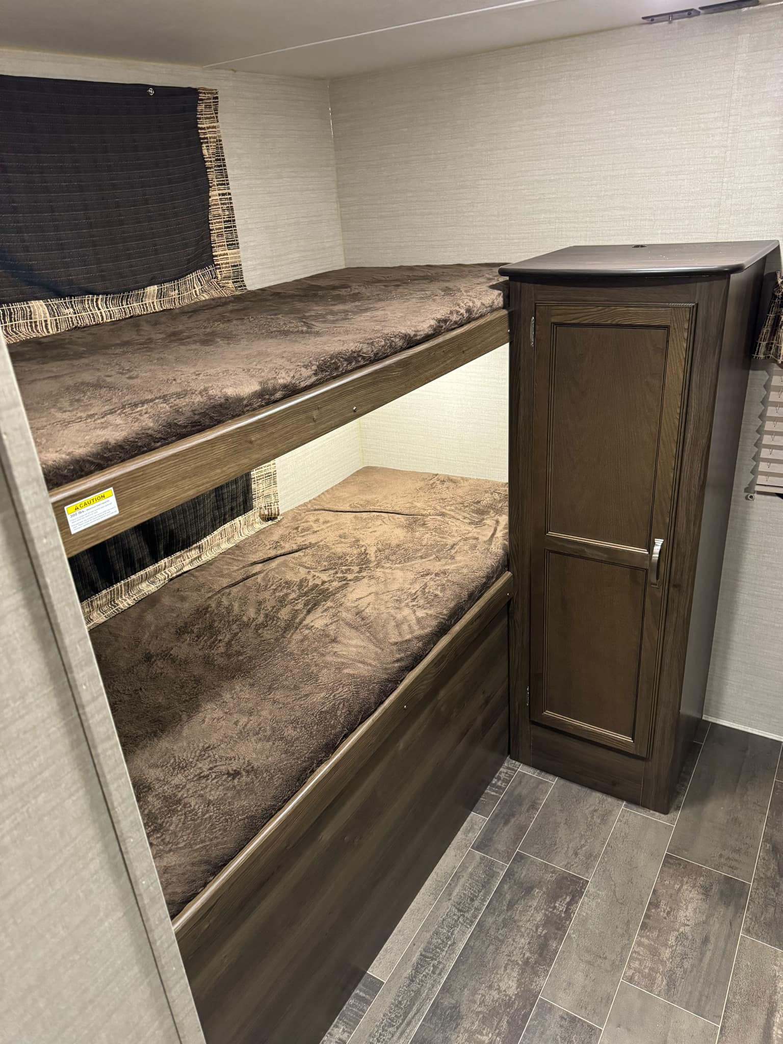 RV rental: Cozy brown bunk beds and storage cabinet on textured gray tile-look flooring.. Keystone RV Bullet Ultra Lite 2019