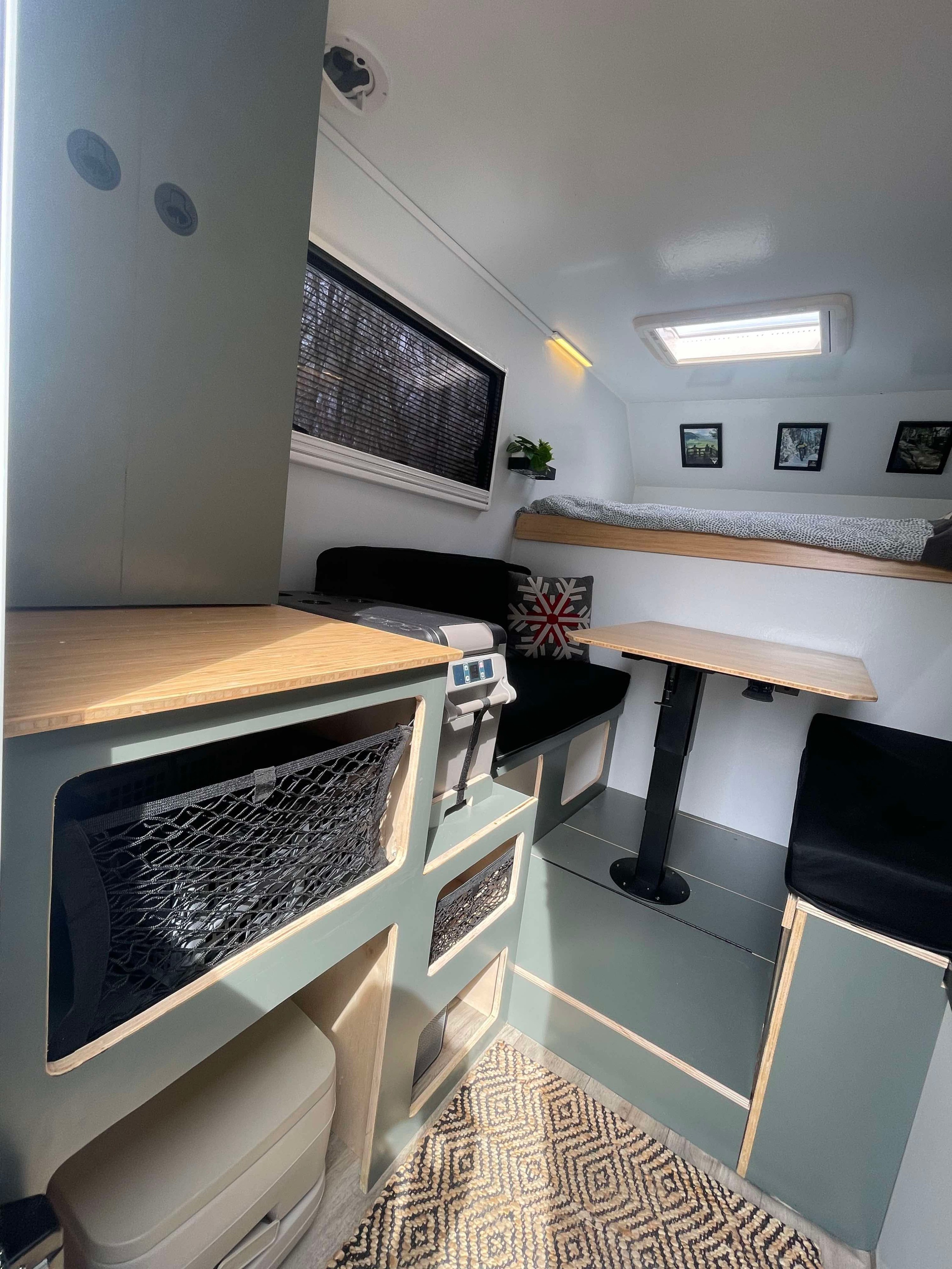 Bright RV rental interior: cozy bunk bed, dining space with adjustable table, compact kitchen counter, and integrated storage nets.. Ford Lightning 2024