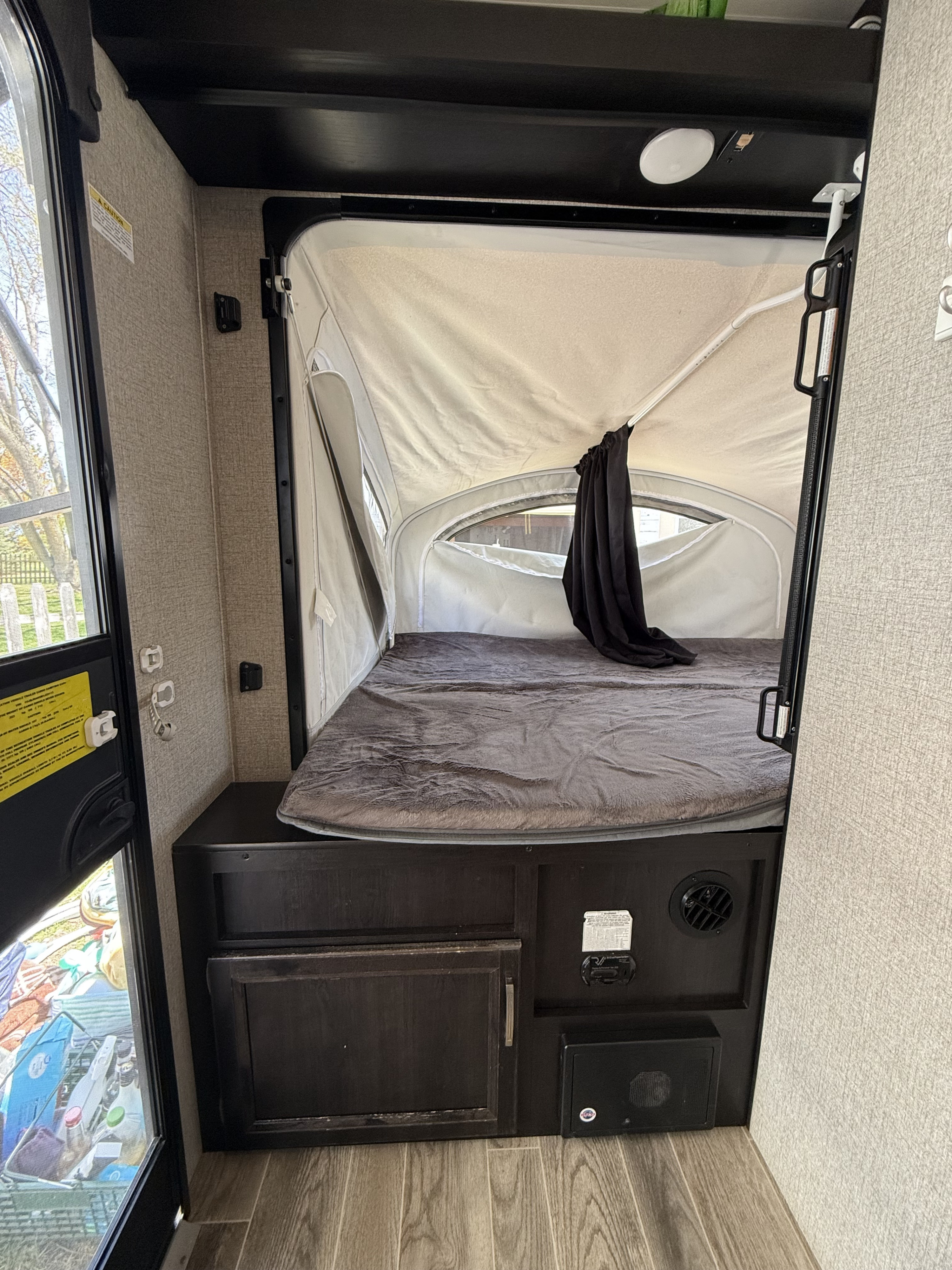 Inside an RV rental: a spacious pop-out bed and sleeping area. Perfect for a comfortable camping or travel experience.. Jayco Jay Feather 2021