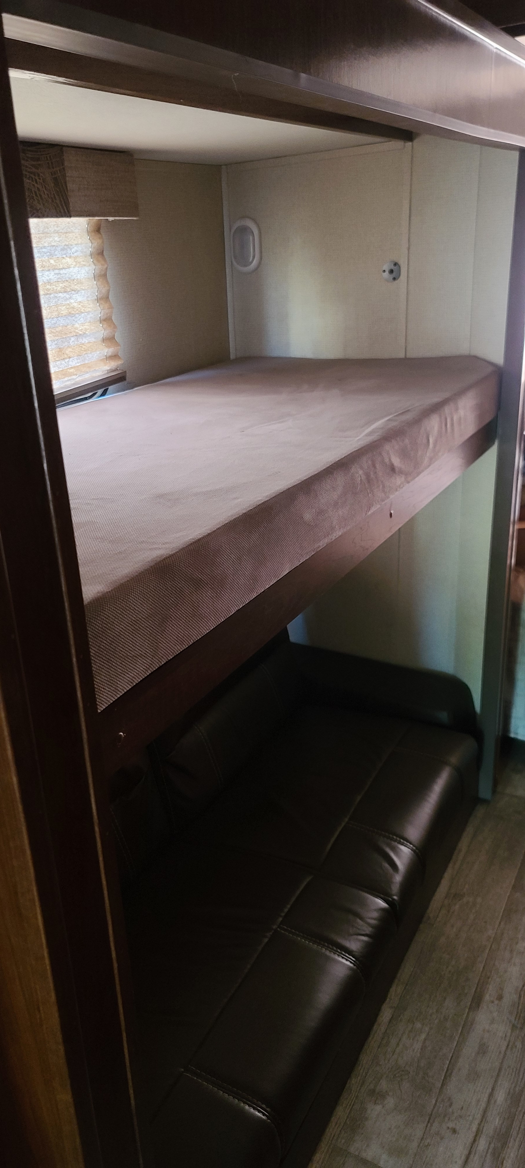 RV rental interior features: upper bunk bed with a brown mattress over a dark brown sofa, alongside a window.. FR3 FR3 Motorhome 2018