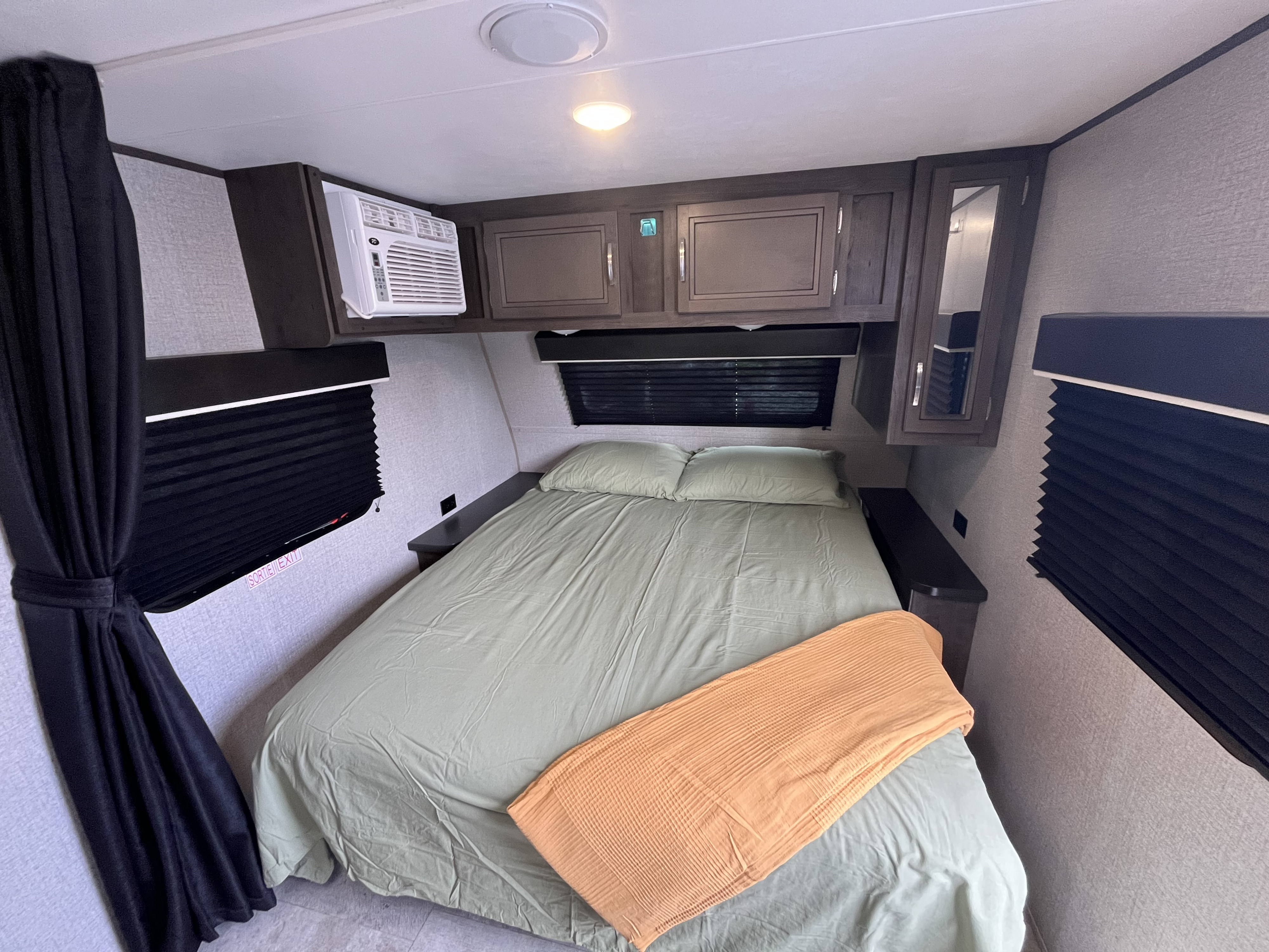 Cozy RV rental bedroom featuring a comfortable bed, AC, and window blinds. Perfect for your next adventure.. Jayco Jay Flight SLX Baja Edition 2020