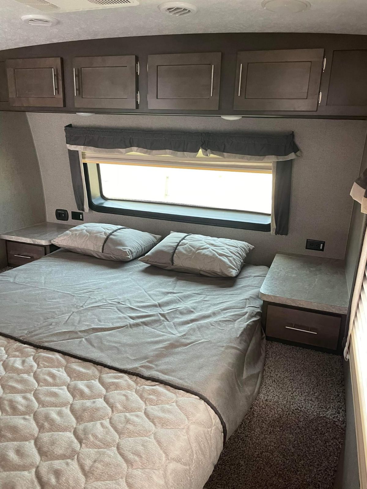 Comfortable RV rental bedroom with queen bed, nightstands, window, and overhead storage. Ideal for your next trip.. Forest River Rockwood Ultra Lite 2020
