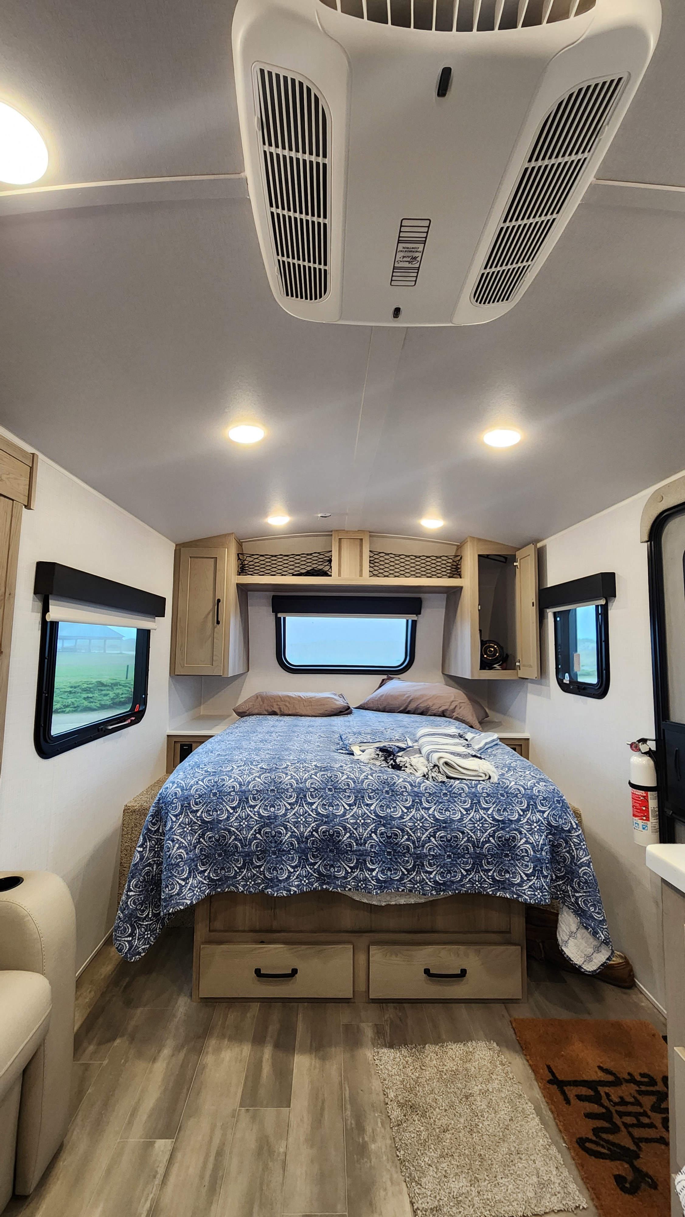 Cozy RV rental bedroom interior with a comfortable bed, built-in storage, and essential overhead AC unit. Perfect for travel.. Forest River Rockwood Geo Pro 2024