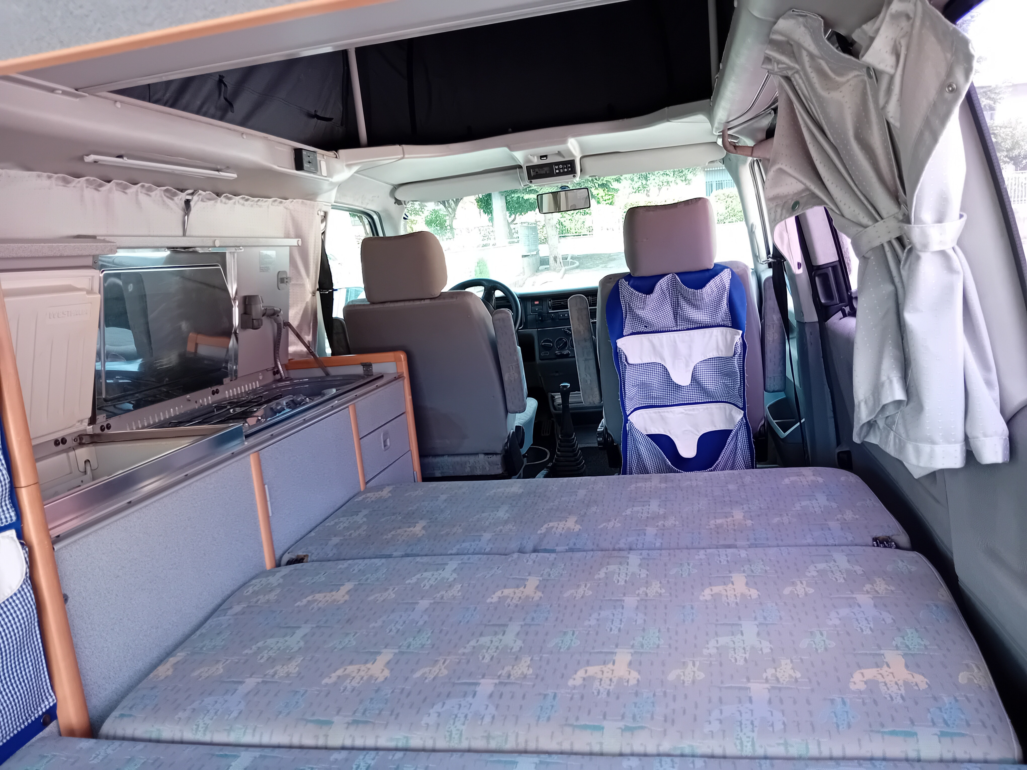 Functional camper van interior: compact kitchen, comfortable bed, and front cabin seats. Ideal for your next rv rental trip!. Volkswagen T4 California TDI 1998
