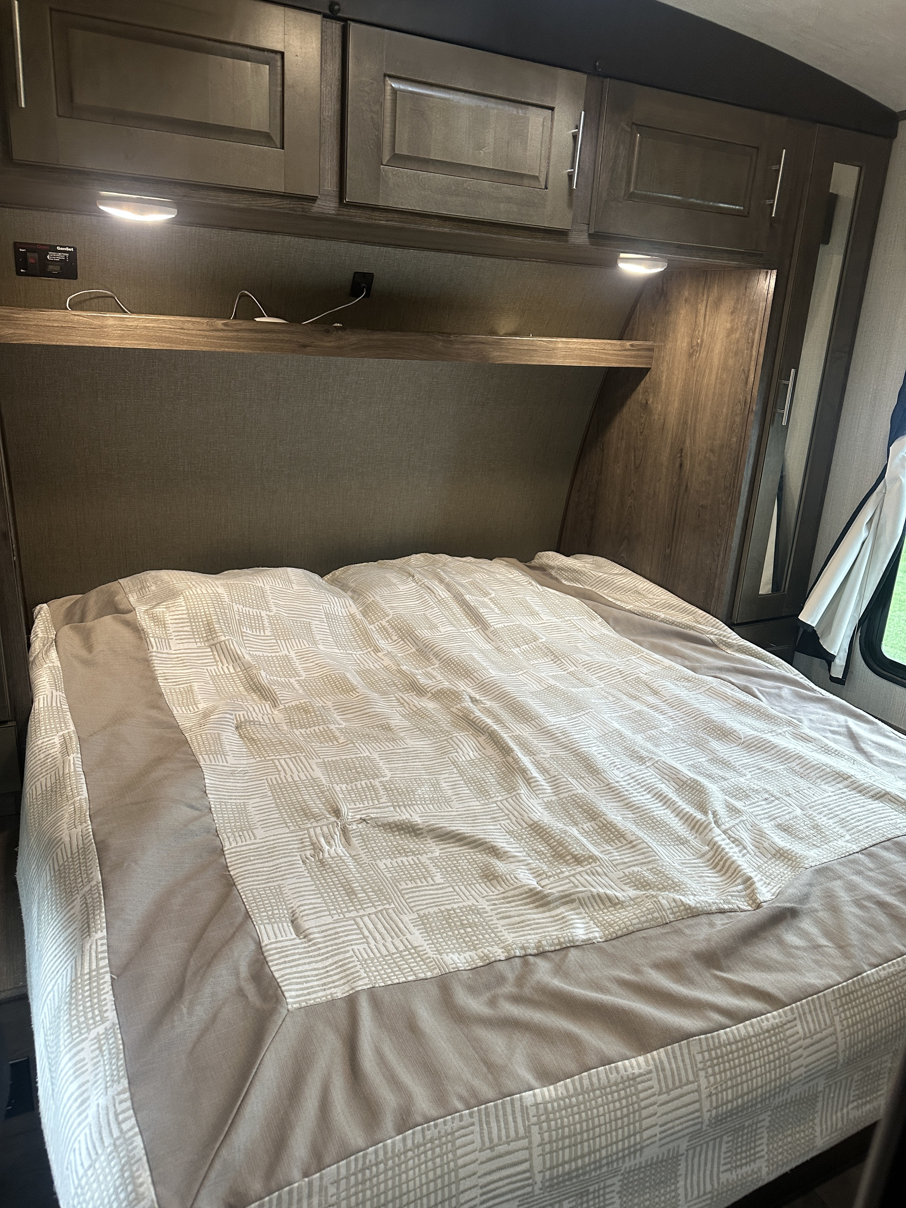 Inside an RV rental: Compact bedroom featuring a comfortable bed, overhead storage, and task lighting.. Heartland Torque 2018