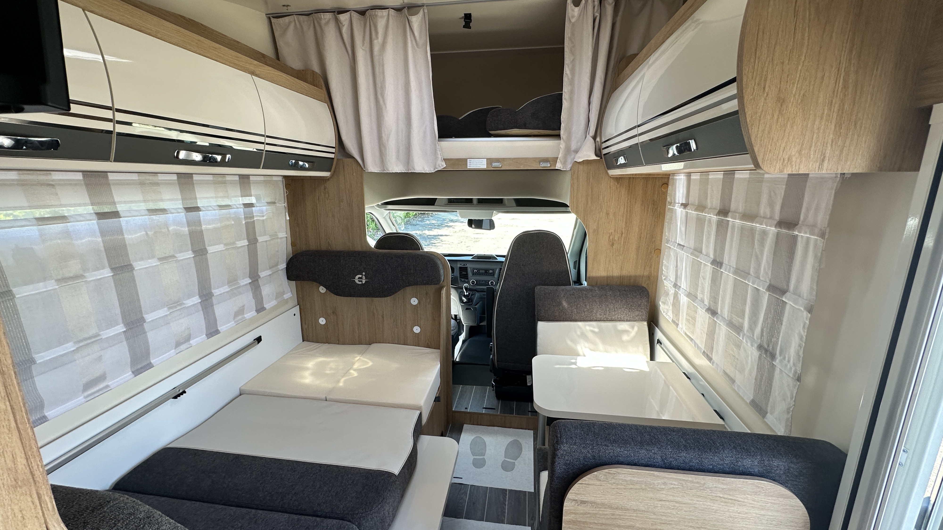 Spacious RV rental interior with convertible beds, dinette, overhead bunk, and ample storage for comfortable travel.. CI HORON 77M 2023
