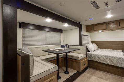 This RV rental interior features a cozy dinette and a comfortable bed, perfect for your travels.. Cherokee WOLF PUP BLACK LABEL 17JWBL 2025