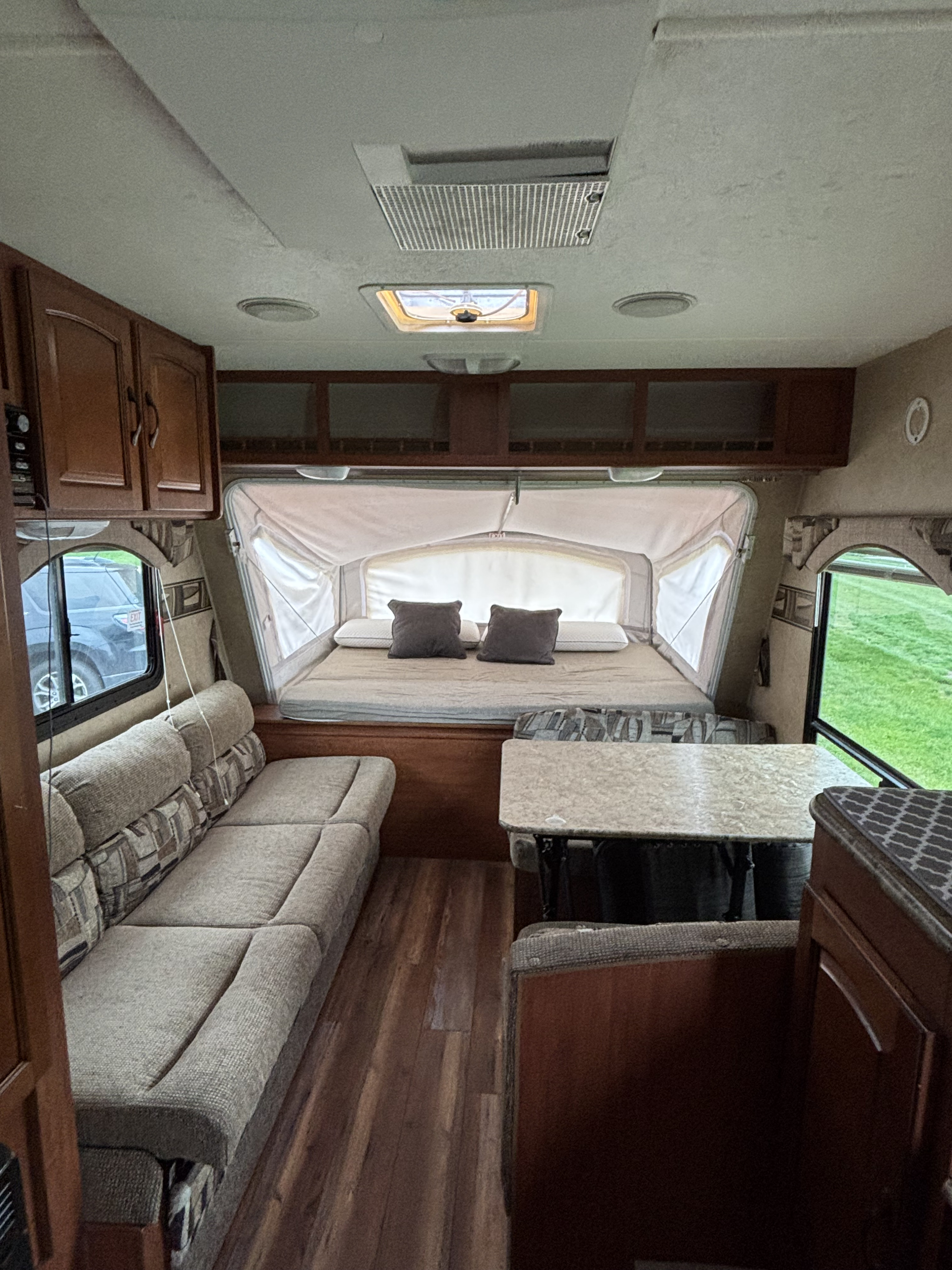 Bright RV rental interior showing a pop-out bed, sofa, and dinette area for comfortable travel.. Forest River Surveyor Sport 2011