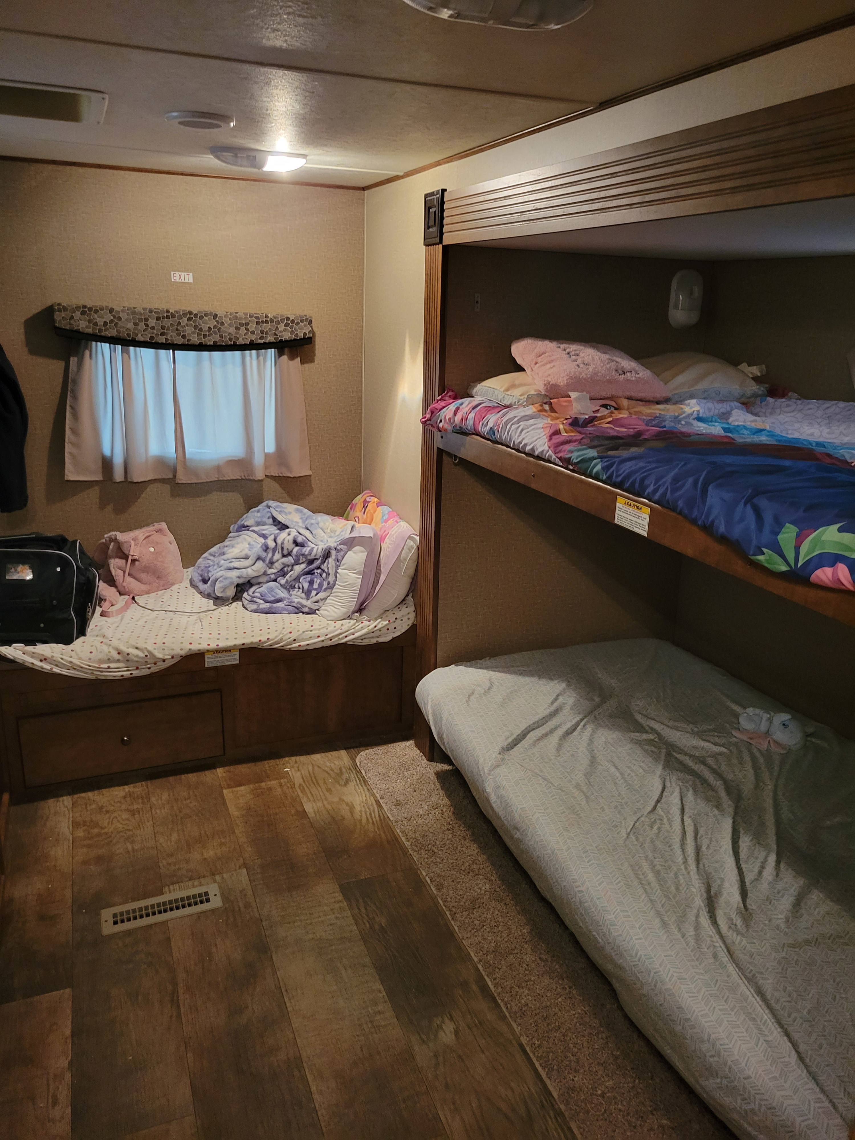 RV rental interior: a cozy sleeping area featuring bunk beds on the right and another bed with storage below a window on the left.. Crossroads RV Z-1 2016