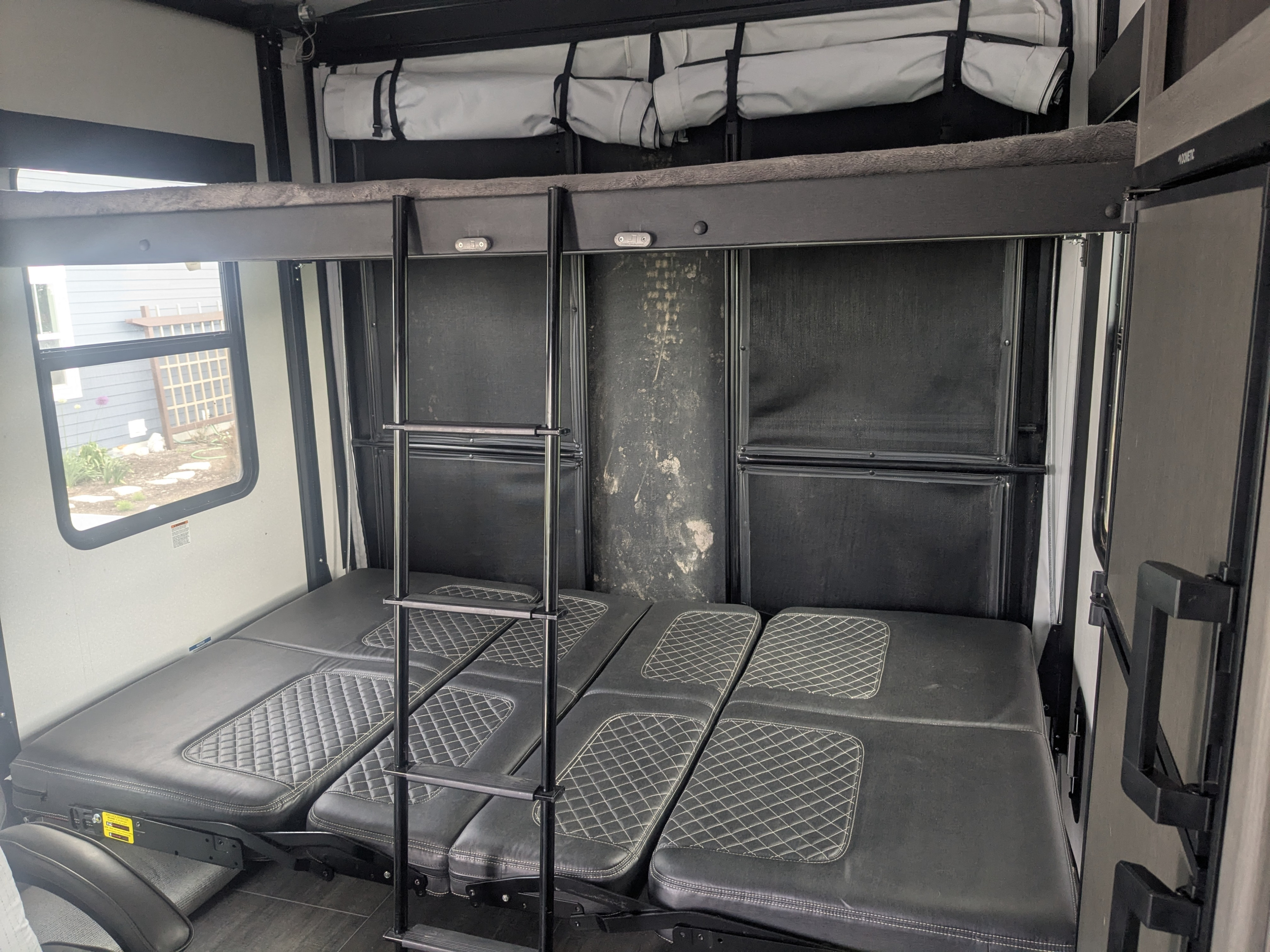 Inside an RV rental: a versatile bunk bed system with lower cushions converting to seating or bed, plus a ladder.. Cruiser Rv Corp Stryker 2022