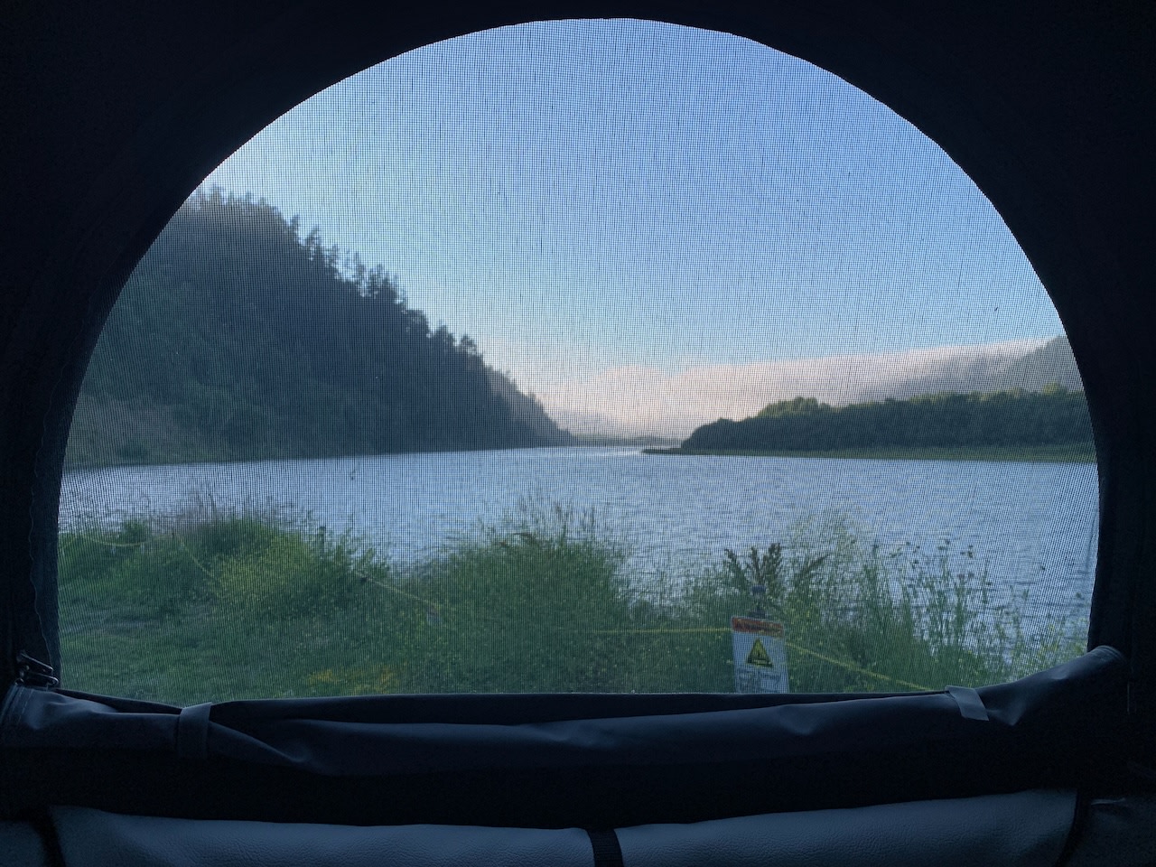 Inside your RV rental: a screened window reveals a tranquil lake, lush mountains, and clear skies, ideal for nature escapes.. Mercedes-Benz Metris 2020