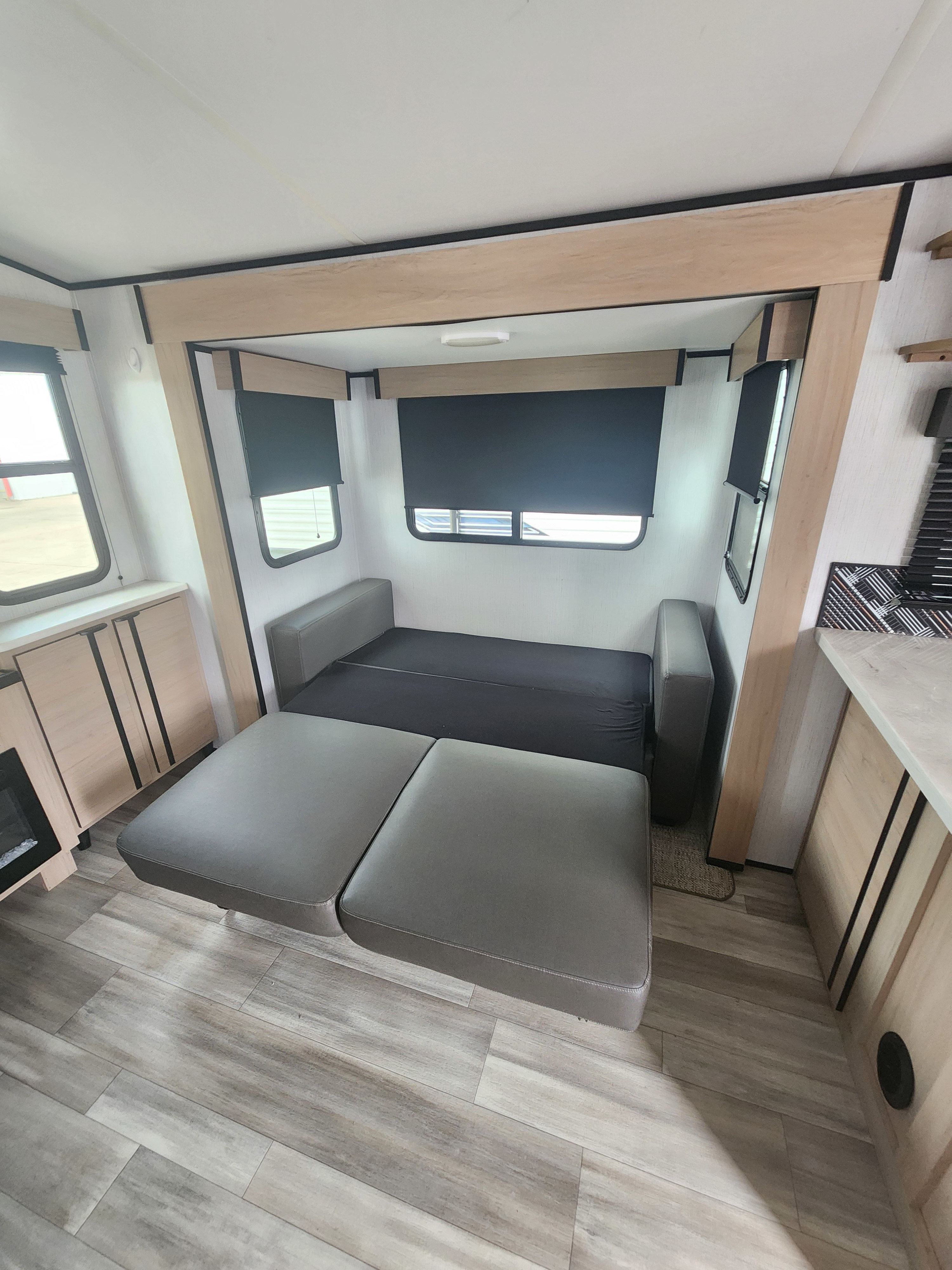Modern RV rental interior with a versatile convertible sofa bed. Ideal for compact travel and living.. Cruiser RV Radiance 2022