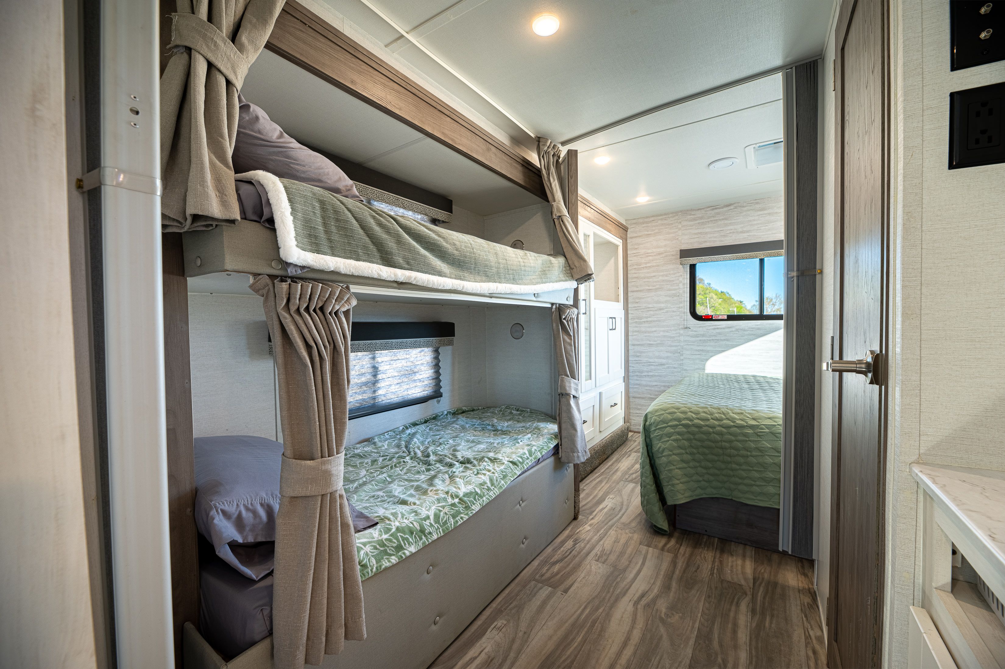 Spacious rv rental interior featuring modern bunk beds & a comfortable main bedroom.. Gulf Stream Conquest 2024