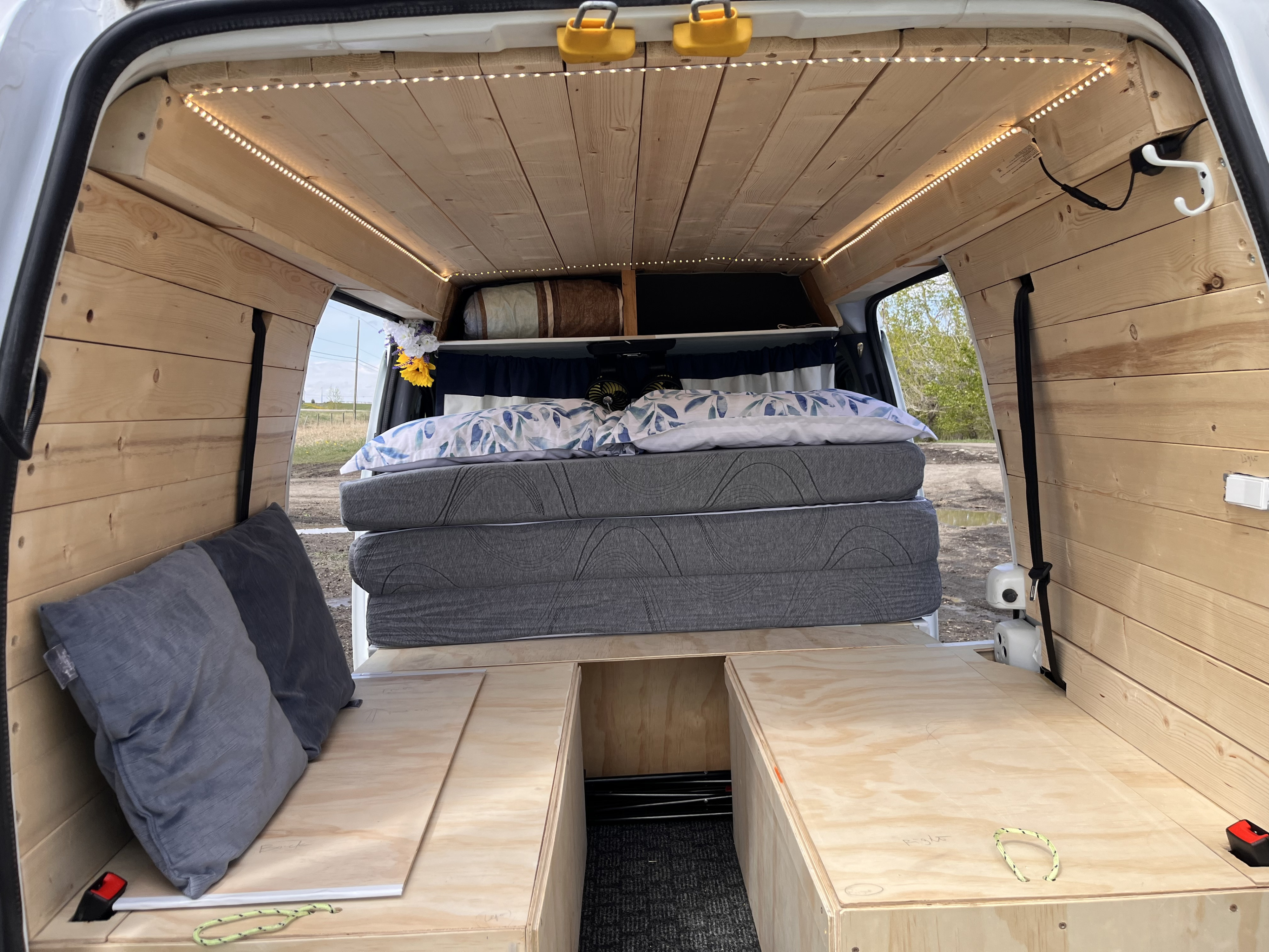 Cozy camper van interior for RV rental. Wooden walls, LED lights, convertible bed, and under-bed storage.. Ford Transit custom 2011