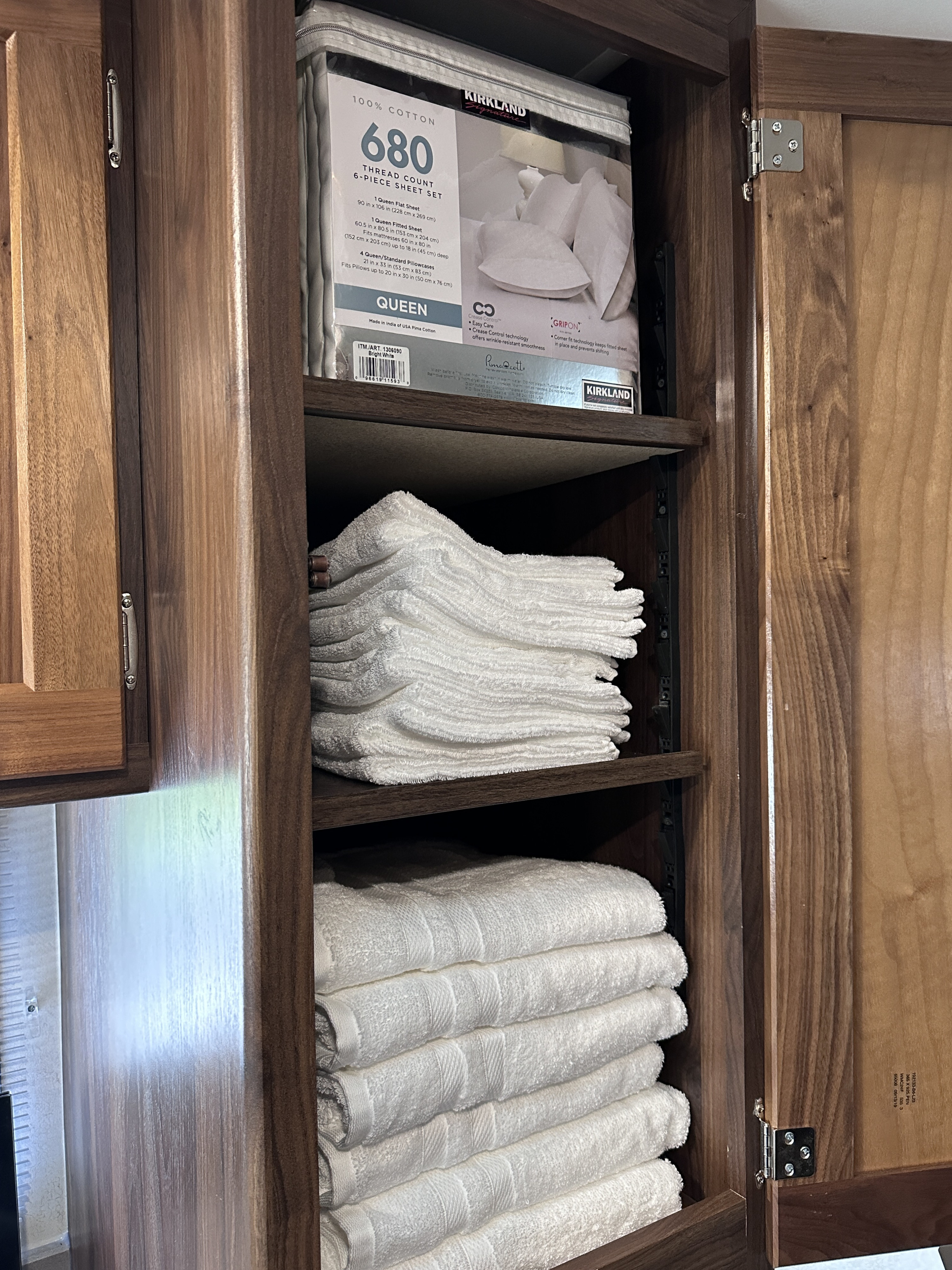 Organized RV rental cabinet showcasing fresh Kirkland bed sheets and fluffy white bath & hand towels.. Winnebago Vita 2020