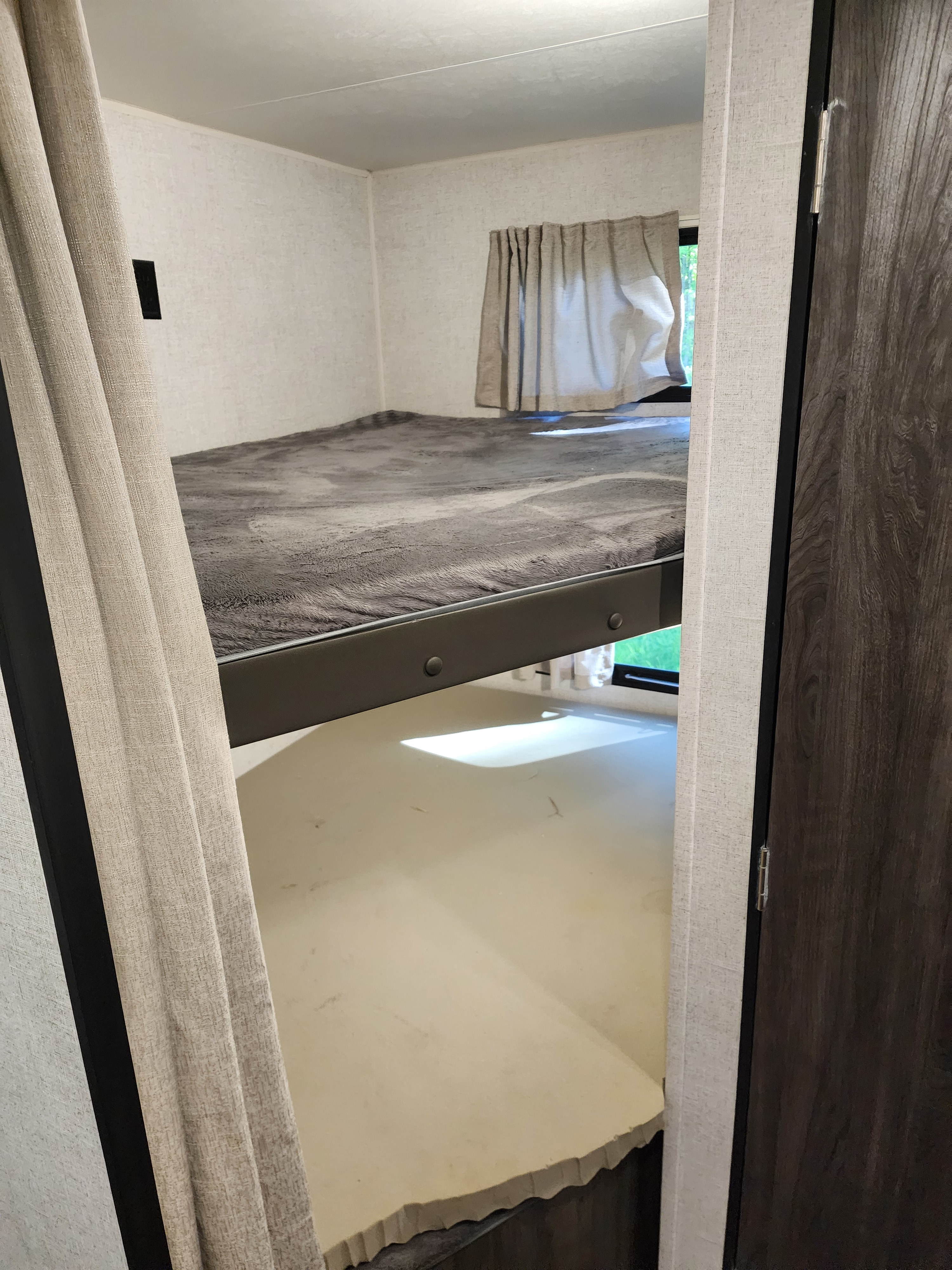 Cozy bunk beds in an RV rental, offering a compact sleeping area with a top bunk and lower platform.. Starcraft Autumn Ridge 2020