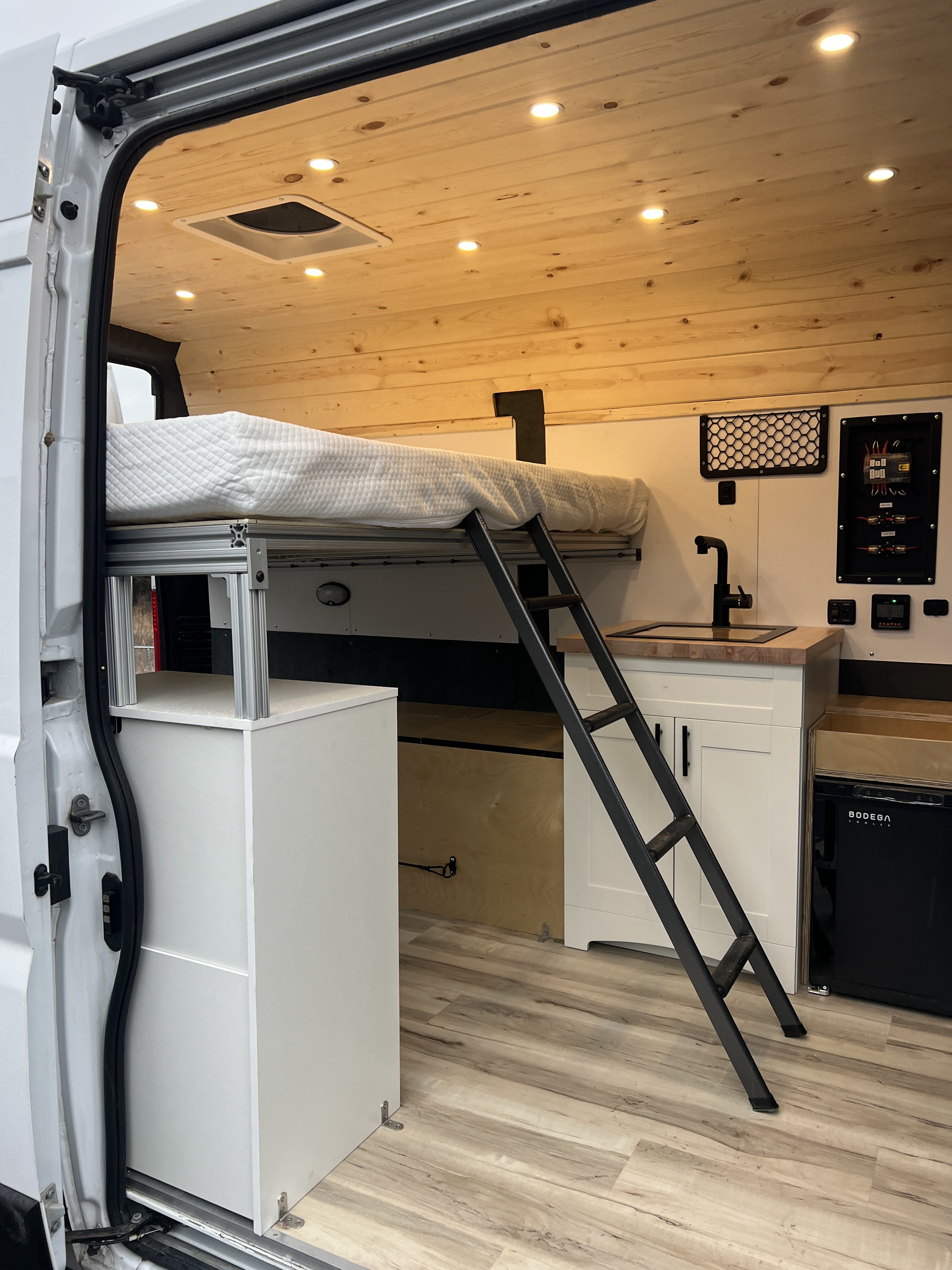 RV rental: Spacious camper van interior with raised bed, kitchen, and ample storage for comfortable mobile living.. Ram Promaster 1500 2020