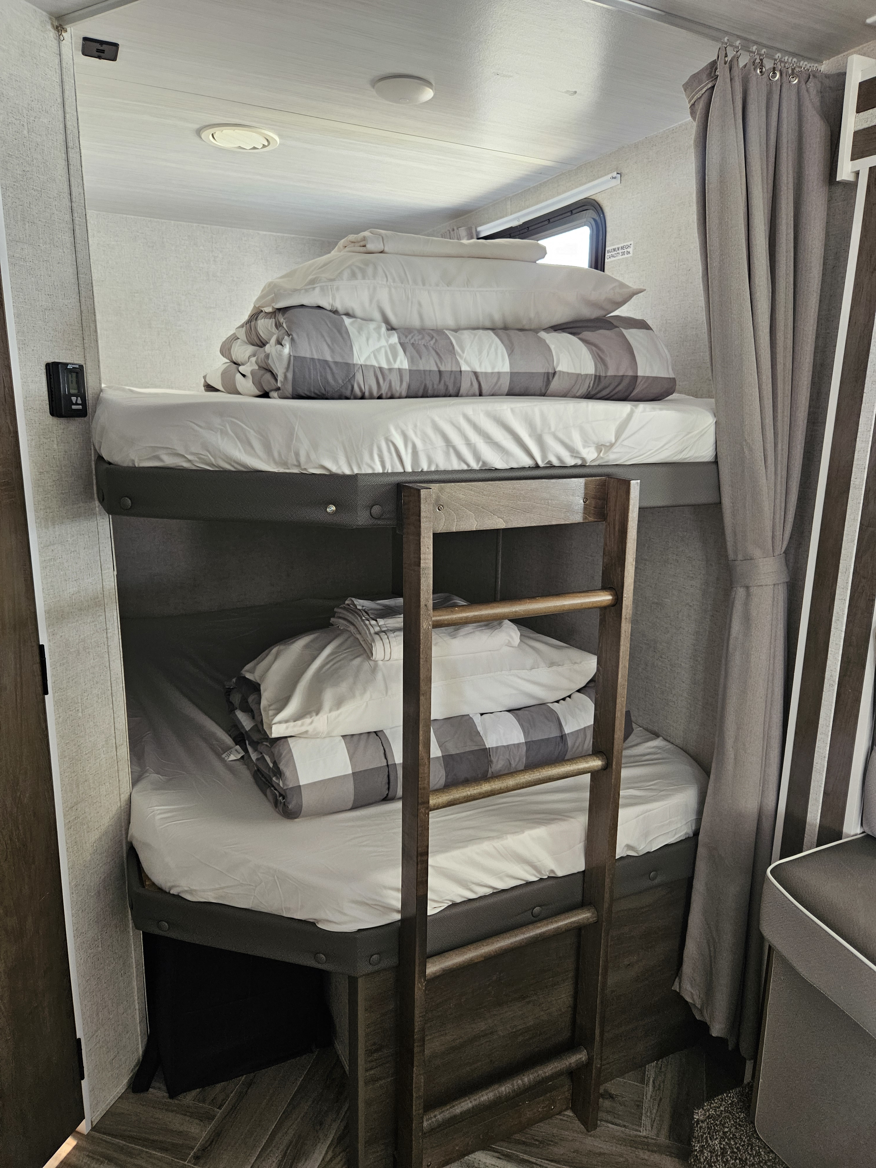 Spacious RV rental bunk beds with fresh linens and a sturdy ladder, ready for your next adventure.. Forest River Wildwood X-Lite 2022