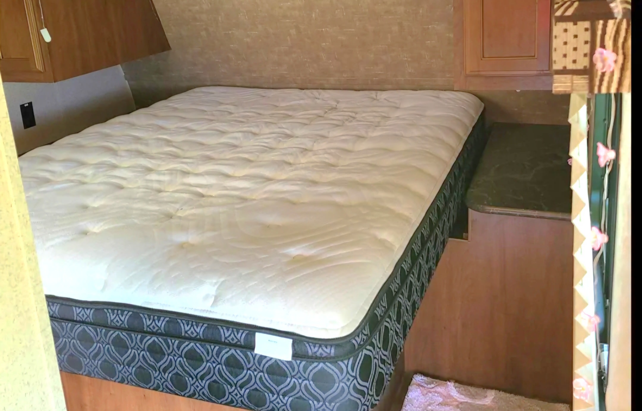 RV rental: Cozy bedroom with a large mattress, featuring a patterned base, overhead cabinets, and a built-in nightstand.. Jayco Jay Flight SLX 2016